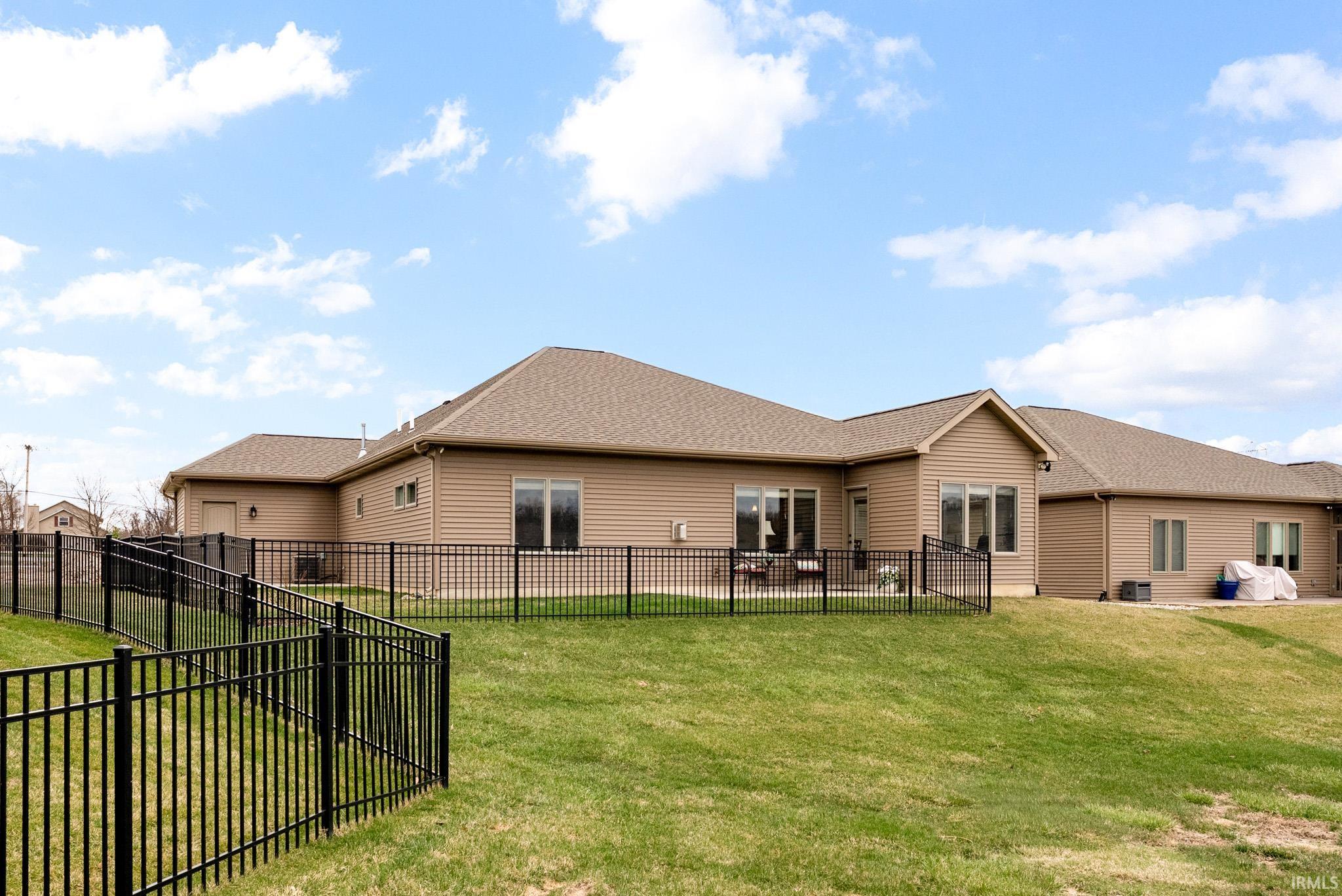 Rear view of property with a fenced backyard and roof with shingles