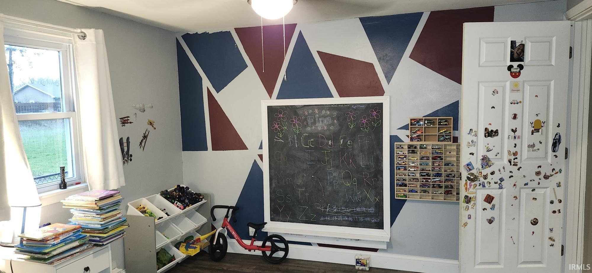 Misc room with dark wood-style flooring and healthy amount of natural light