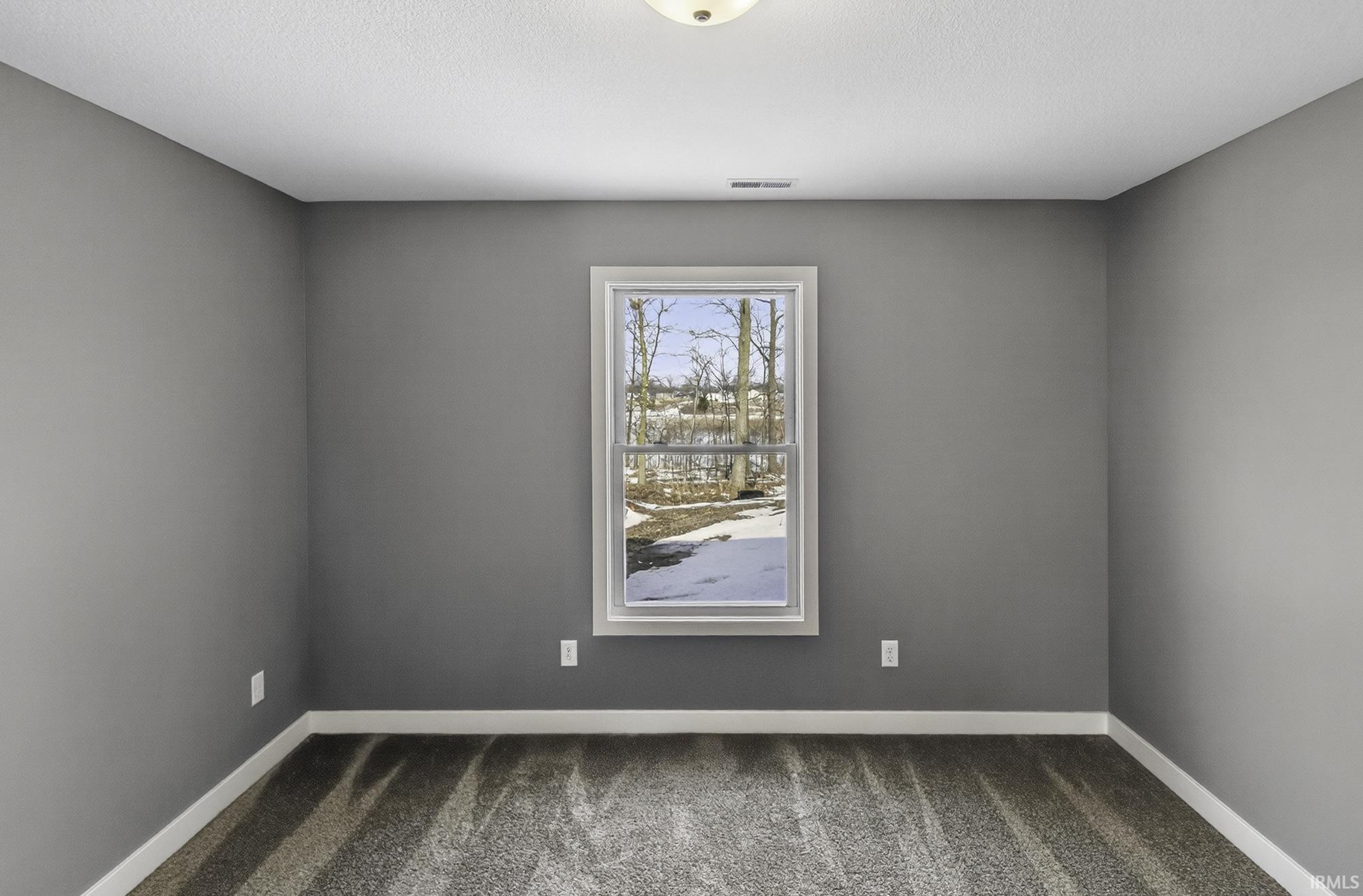 Carpeted empty room featuring baseboards