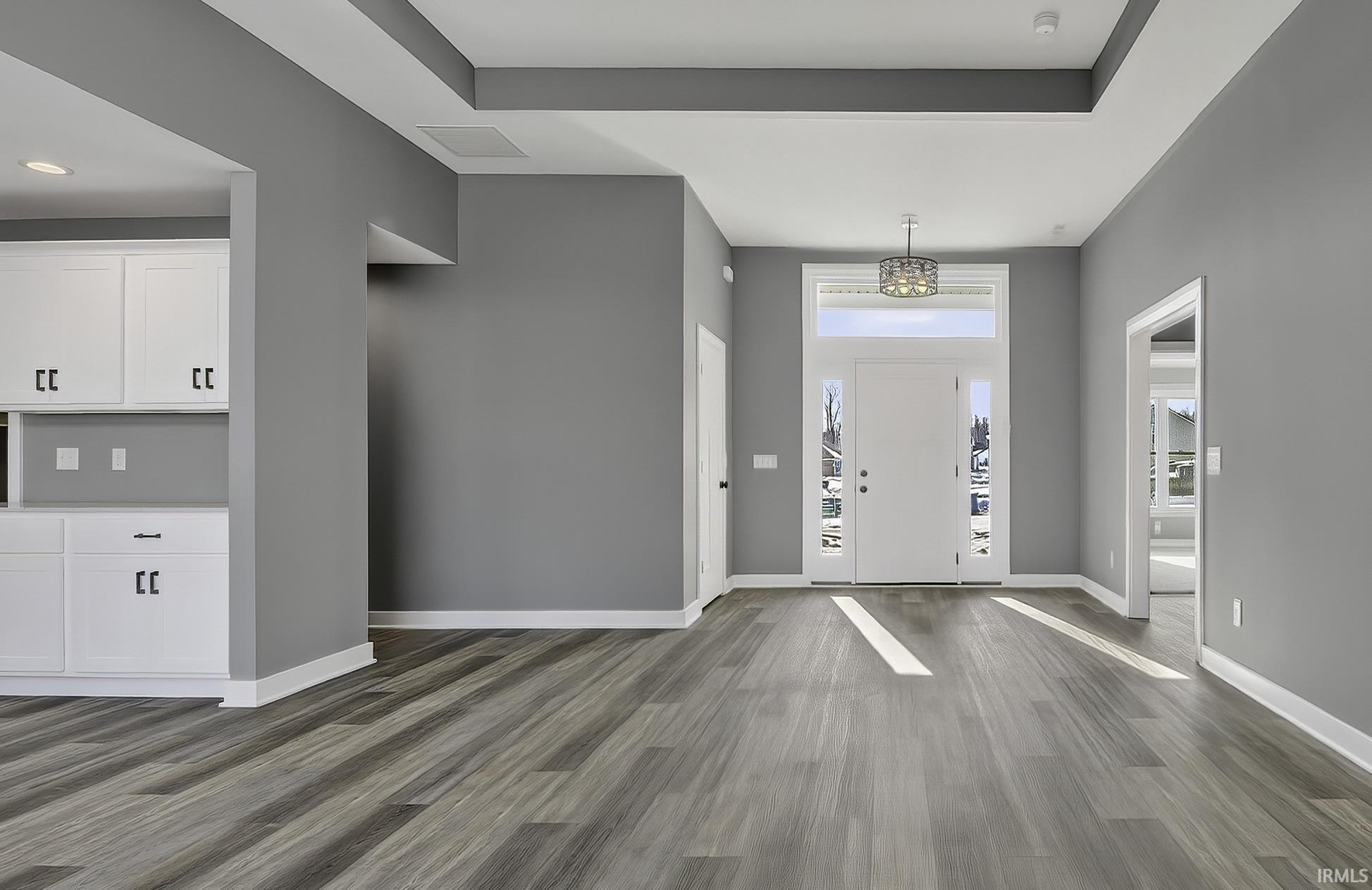 Entryway with dark wood-type flooring and baseboards