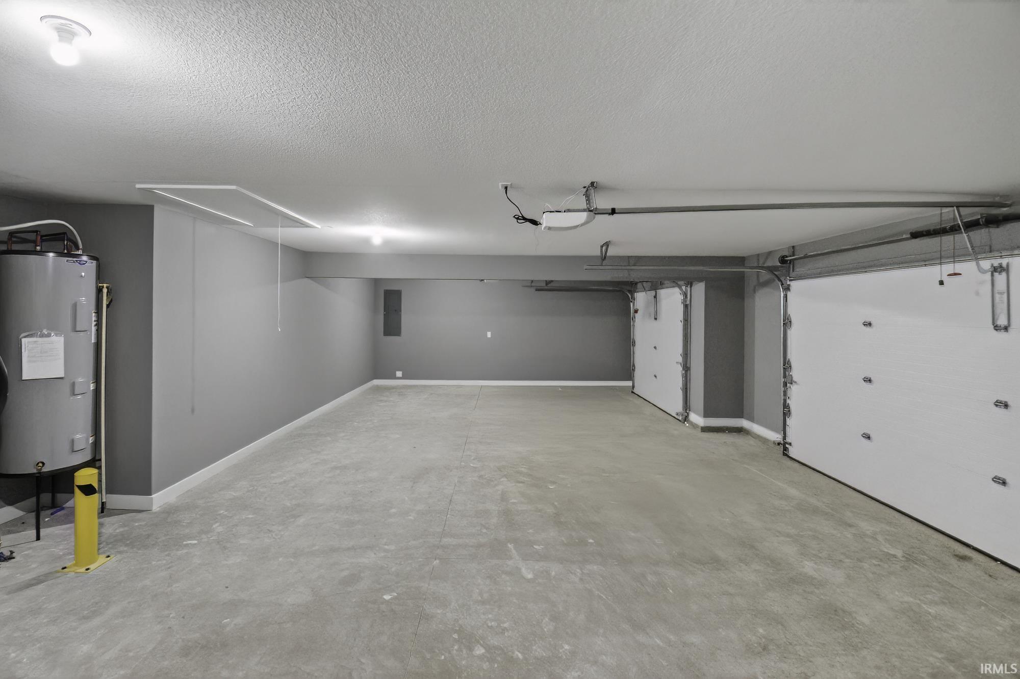 Garage featuring electric water heater and electric panel