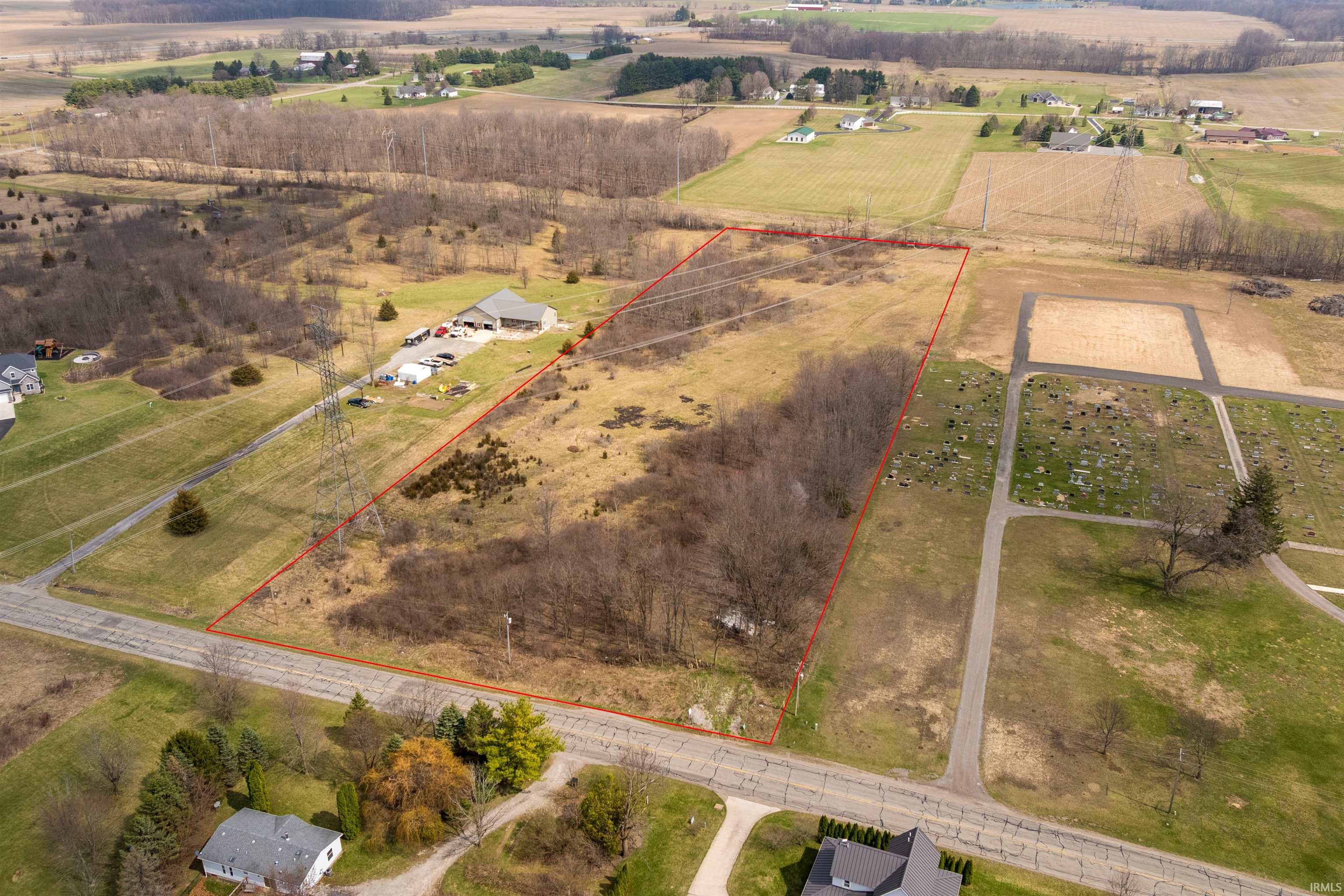 Aerial view of sparsely populated area featuring property boundaries highlighted and rows of crops