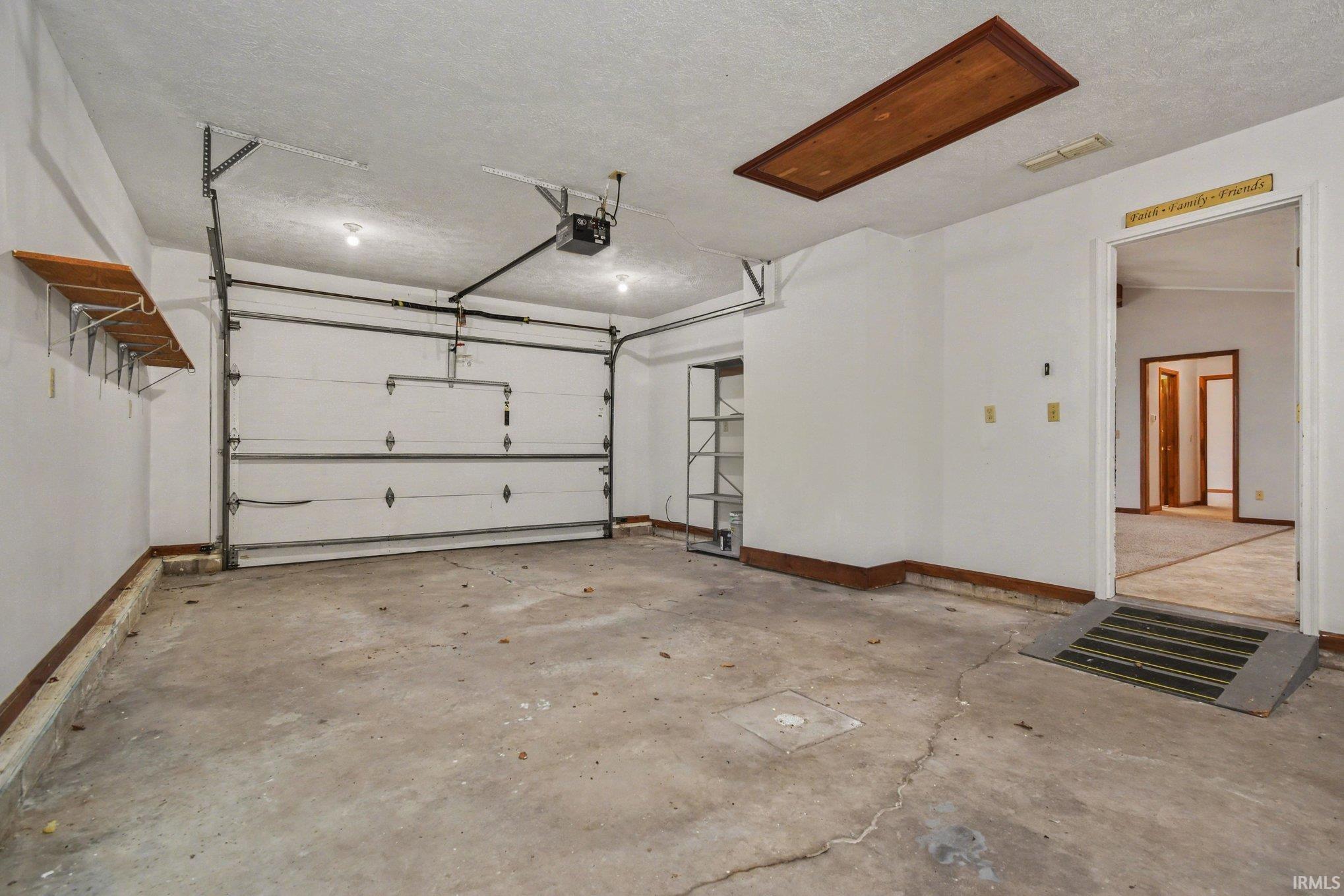 Garage with baseboards and a garage door opener