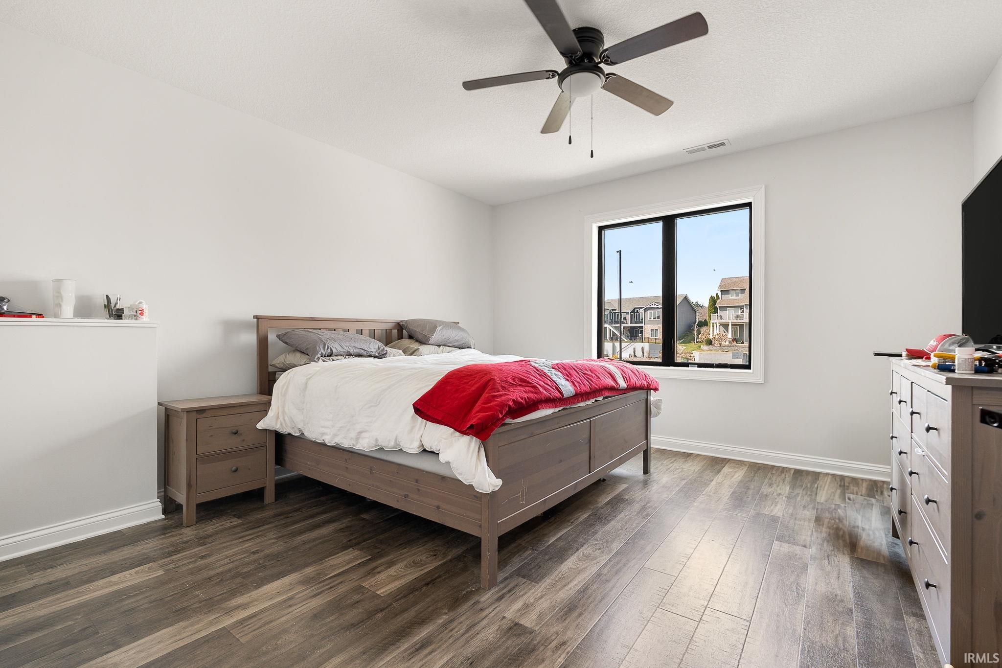 Bedroom with dark wood-style flooring and a ceiling fan