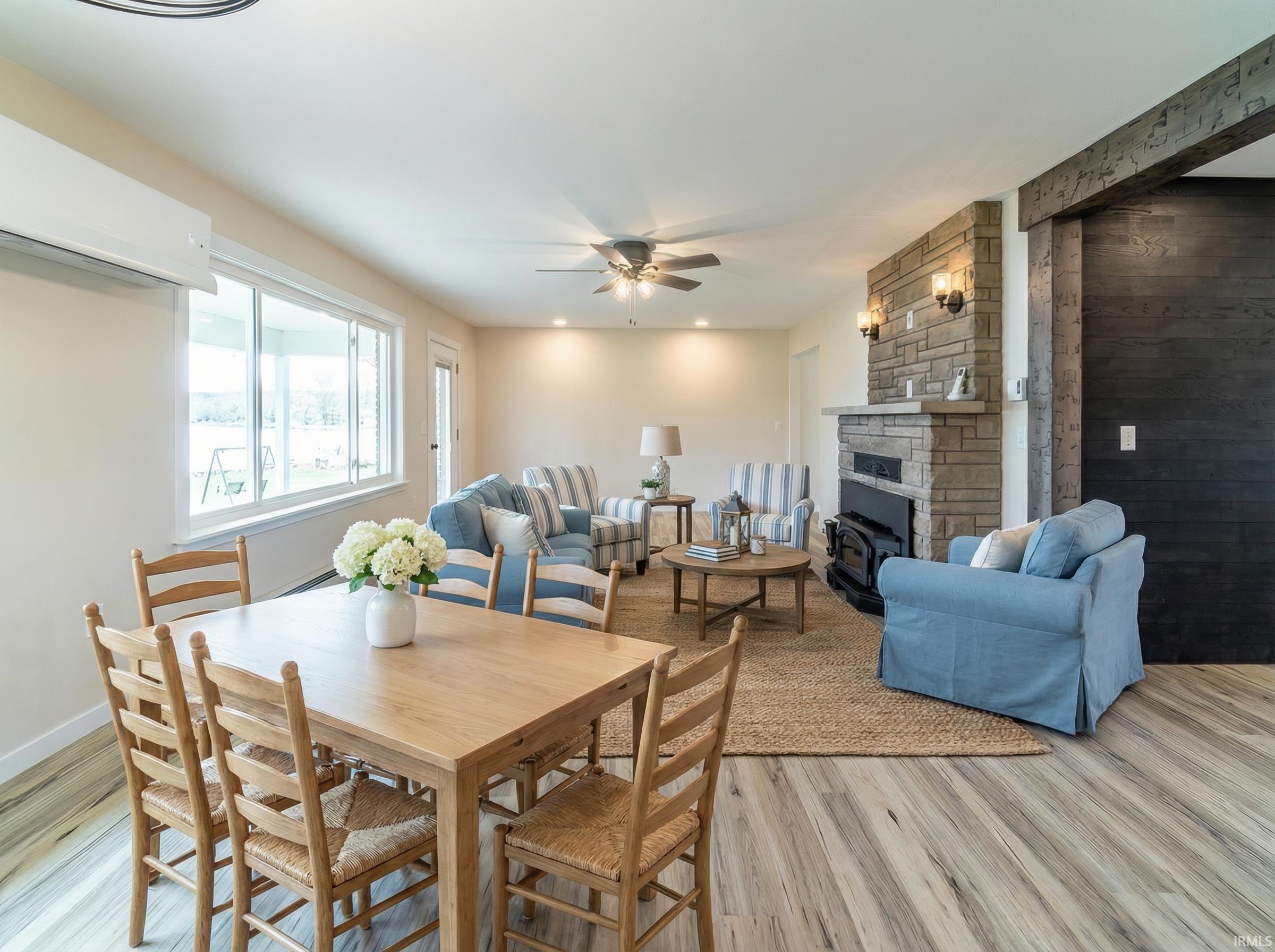 Dining space featuring light wood-style flooring, a ceiling fan, and a fireplace