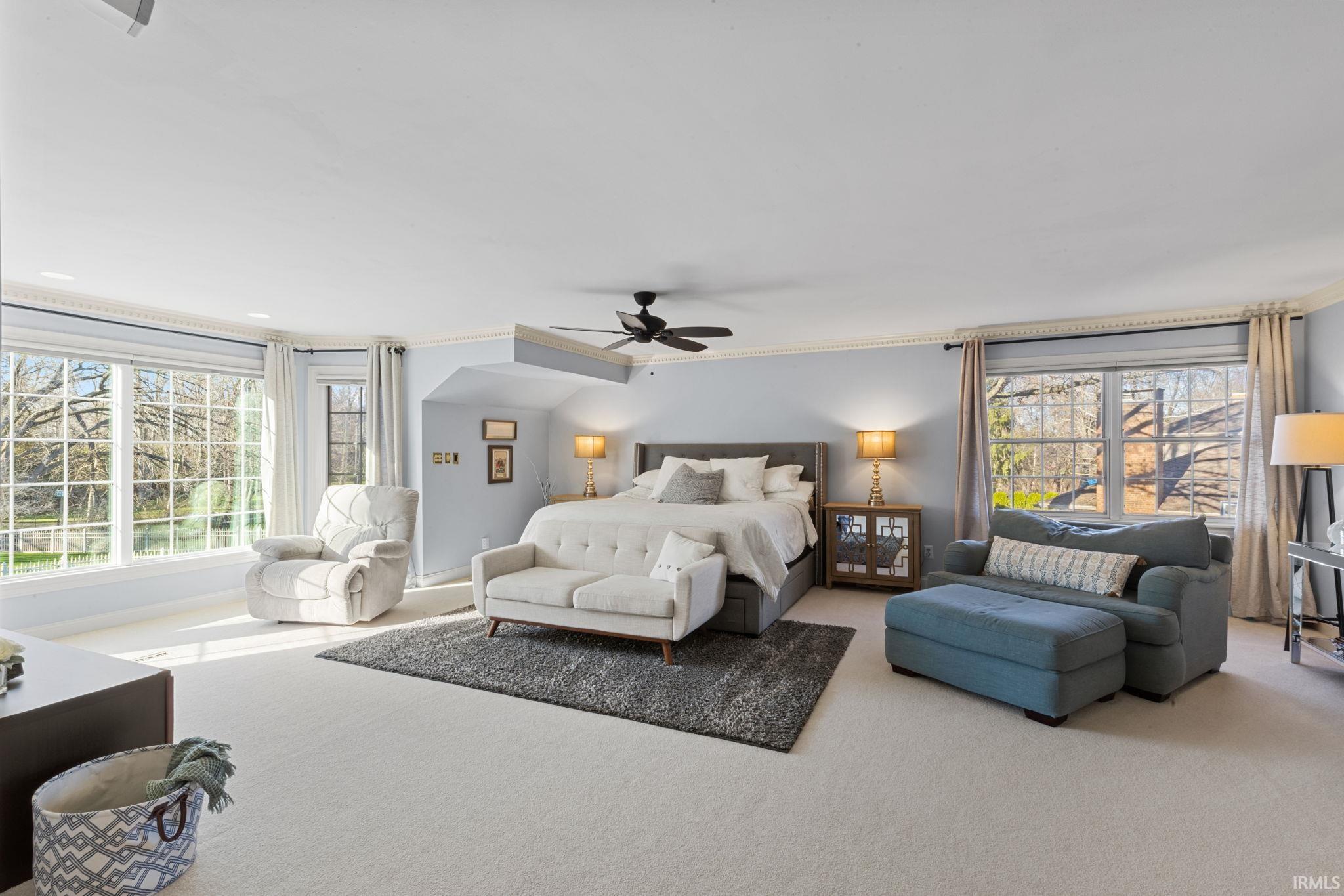Bedroom featuring carpet flooring, ornamental molding, and a ceiling fan