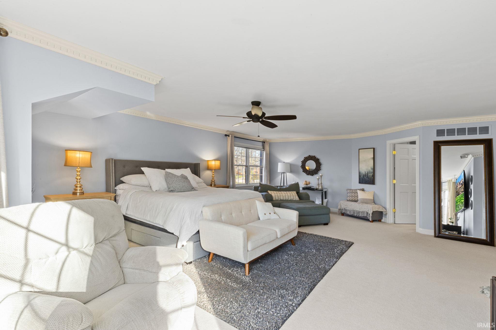 Carpeted bedroom featuring crown molding and a ceiling fan