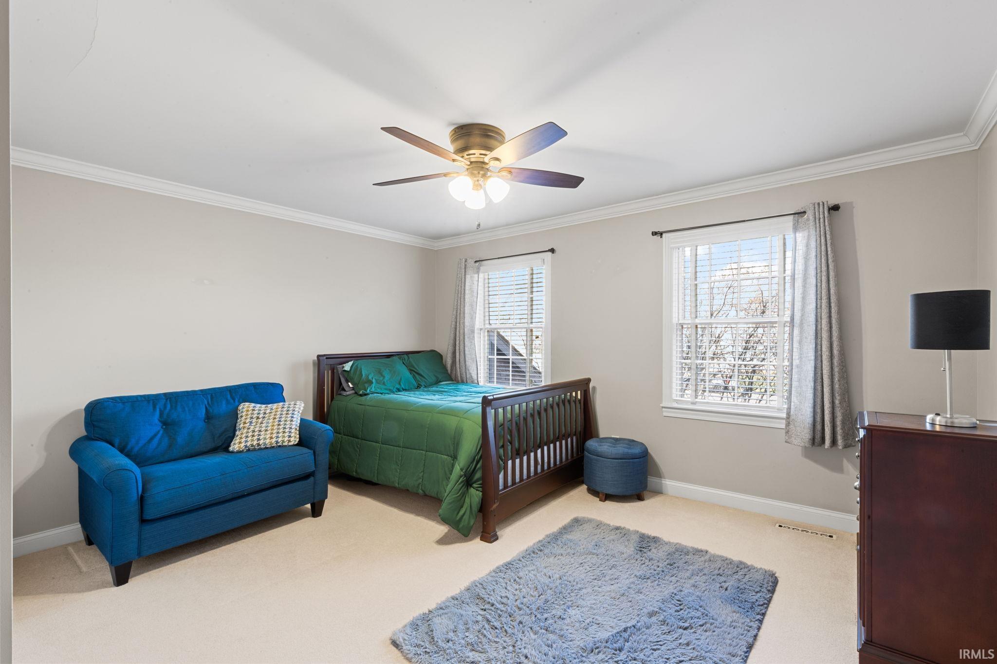 Bedroom featuring crown molding, ceiling fan, and light colored carpet