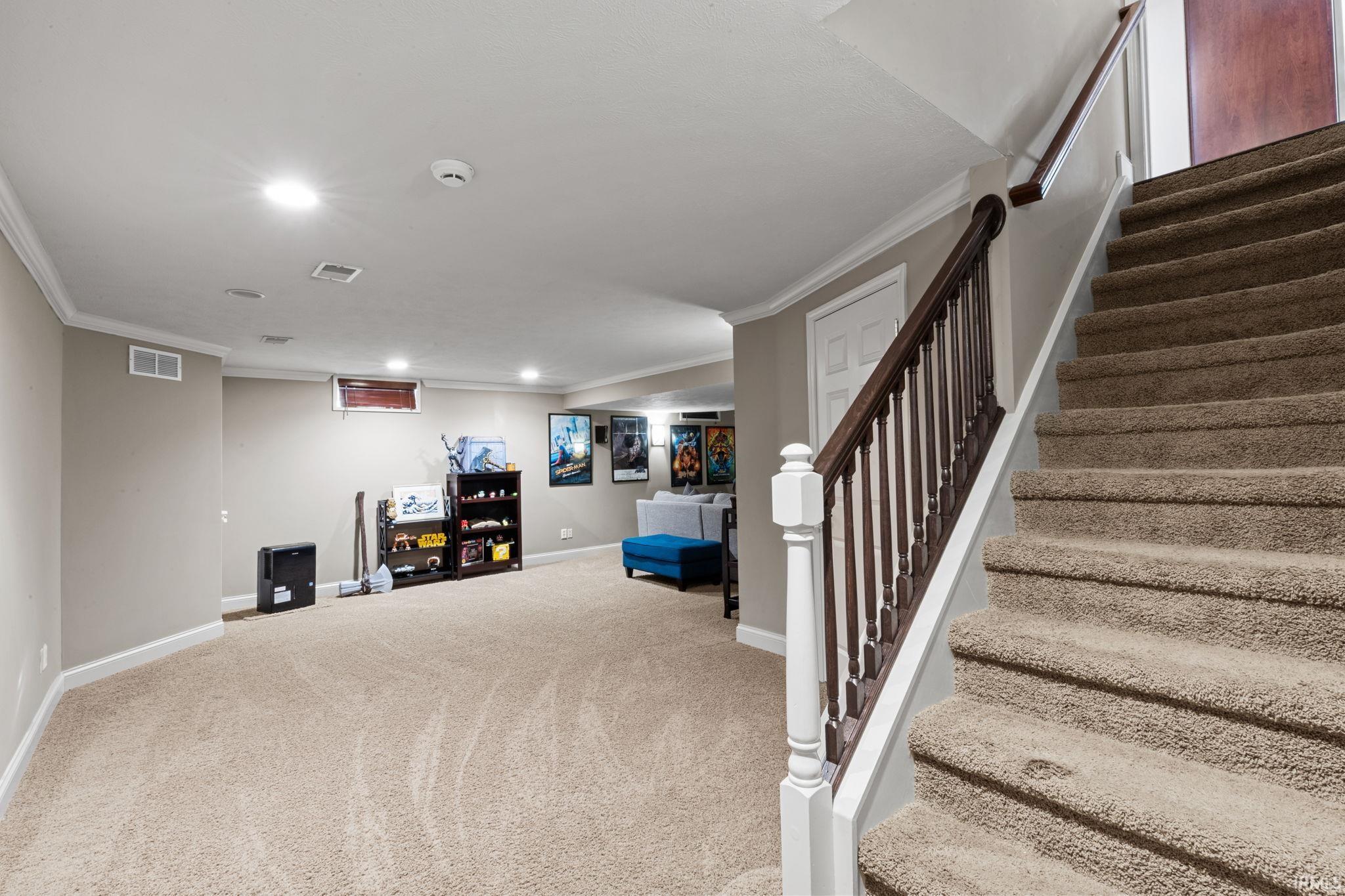 Staircase featuring crown molding, recessed lighting, and carpet flooring