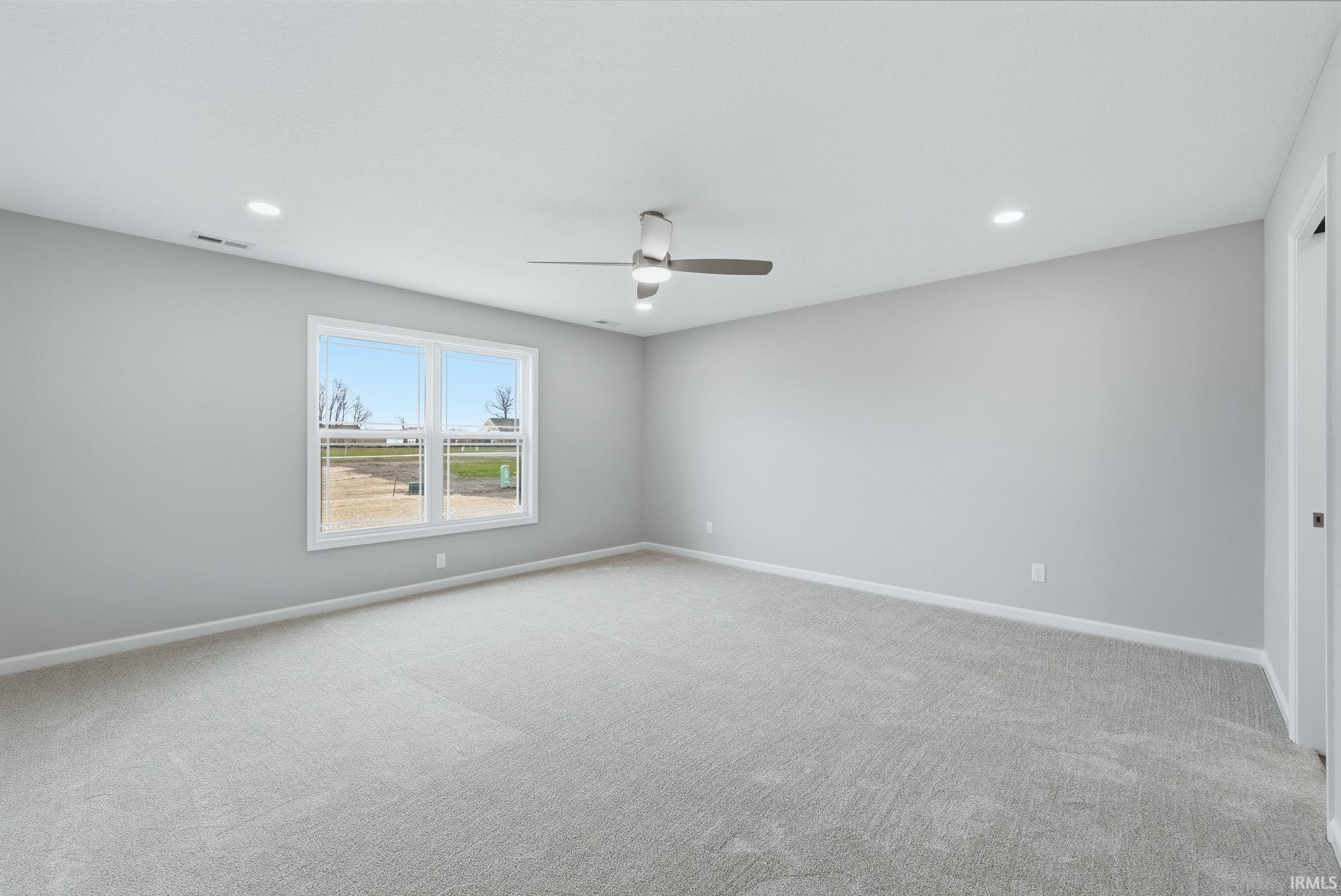 Empty room with light colored carpet, a ceiling fan, and recessed lighting