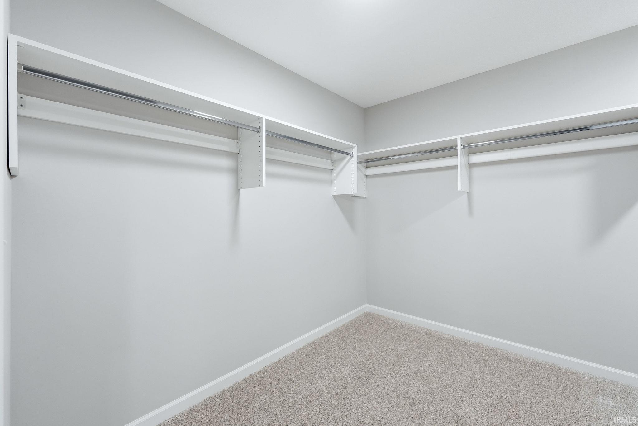 Walk in closet with light carpet