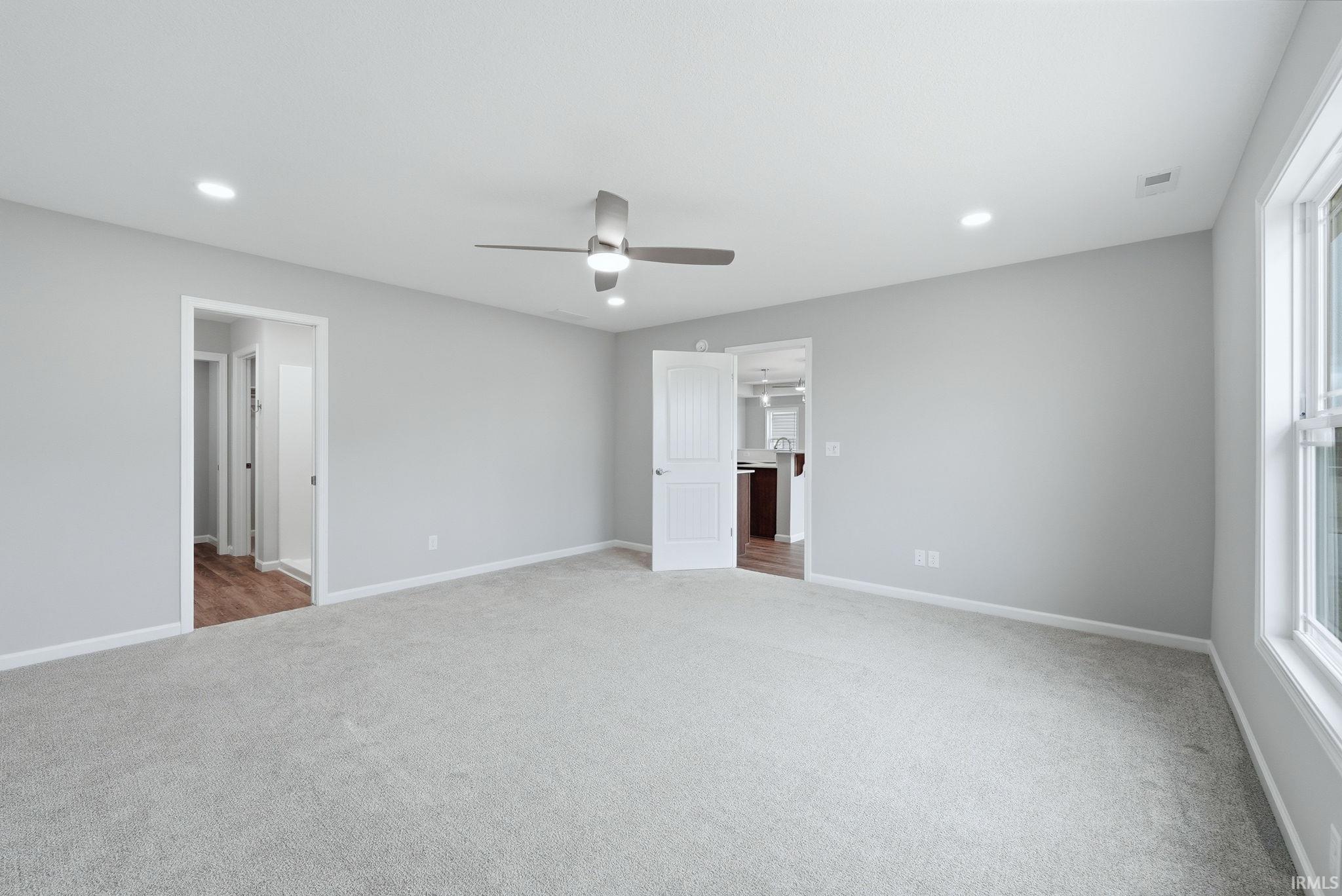 Unfurnished bedroom featuring light carpet, ceiling fan, and recessed lighting