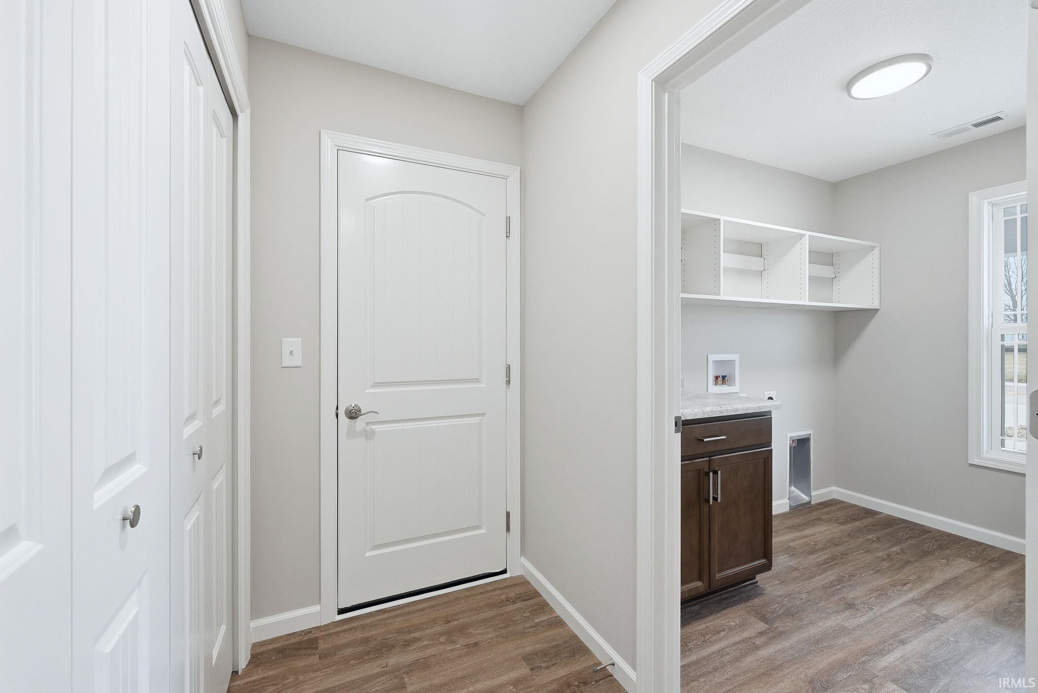 Laundry room featuring dark wood finished floors and hookup for a washing machine