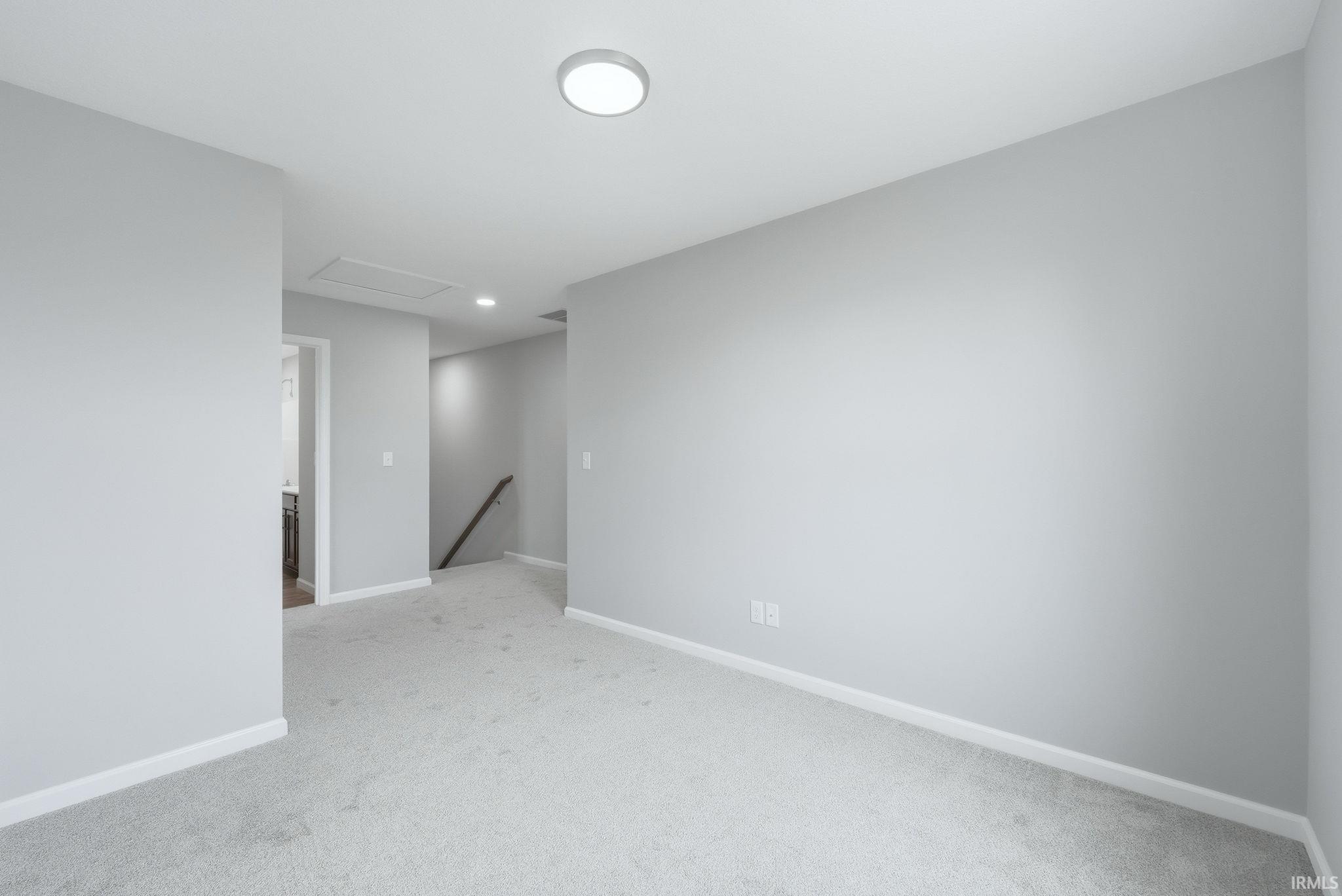 Empty room with baseboards and light colored carpet