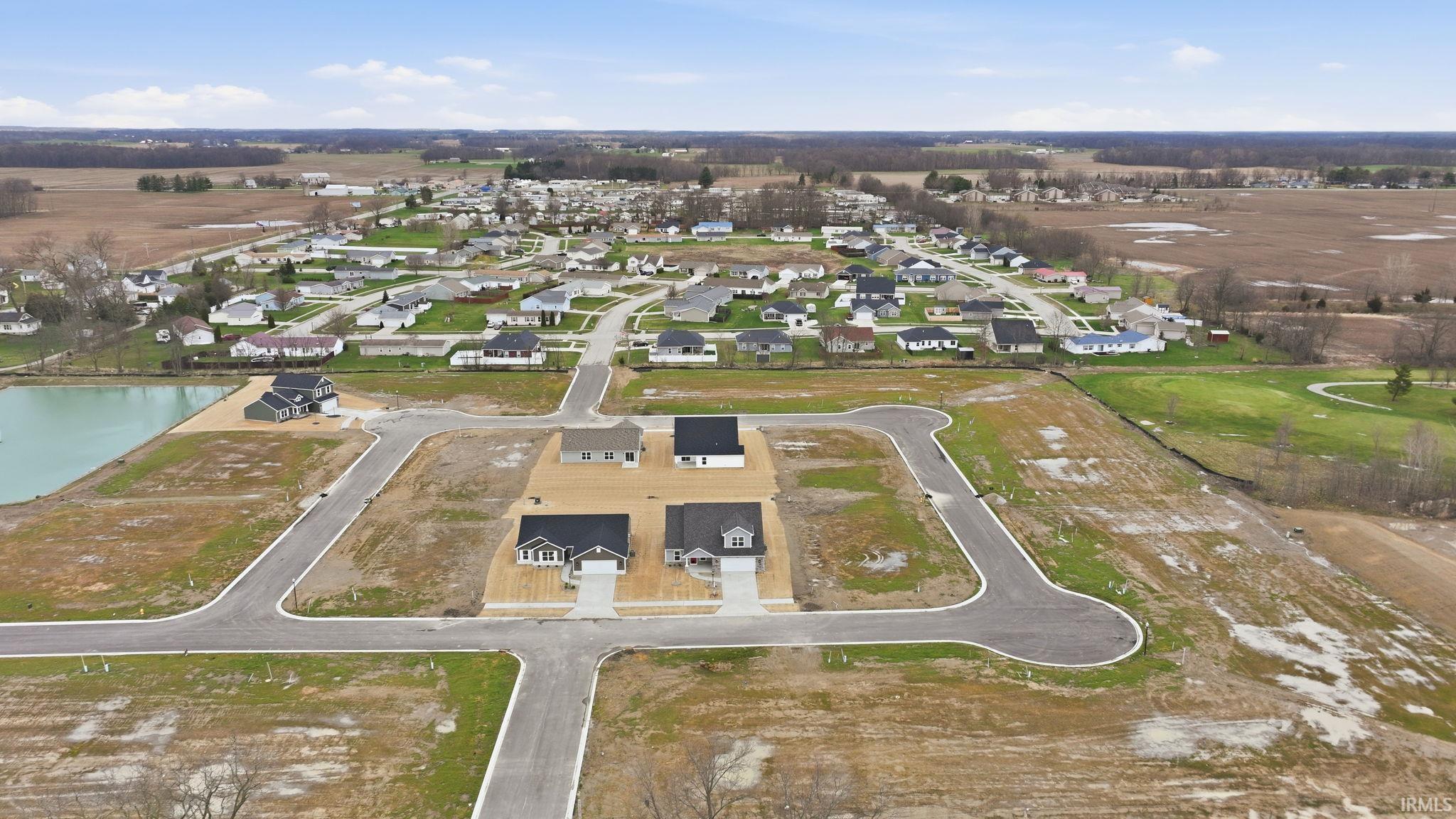 Aerial view of property and surrounding area featuring nearby suburban area and a large body of water