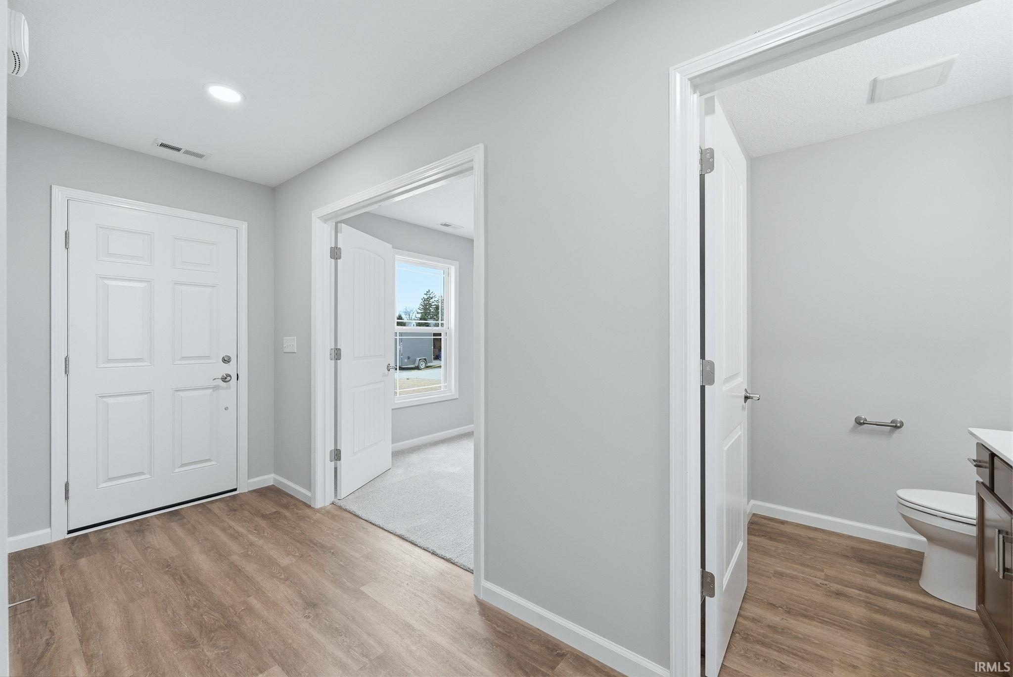 Corridor with light wood finished floors and recessed lighting