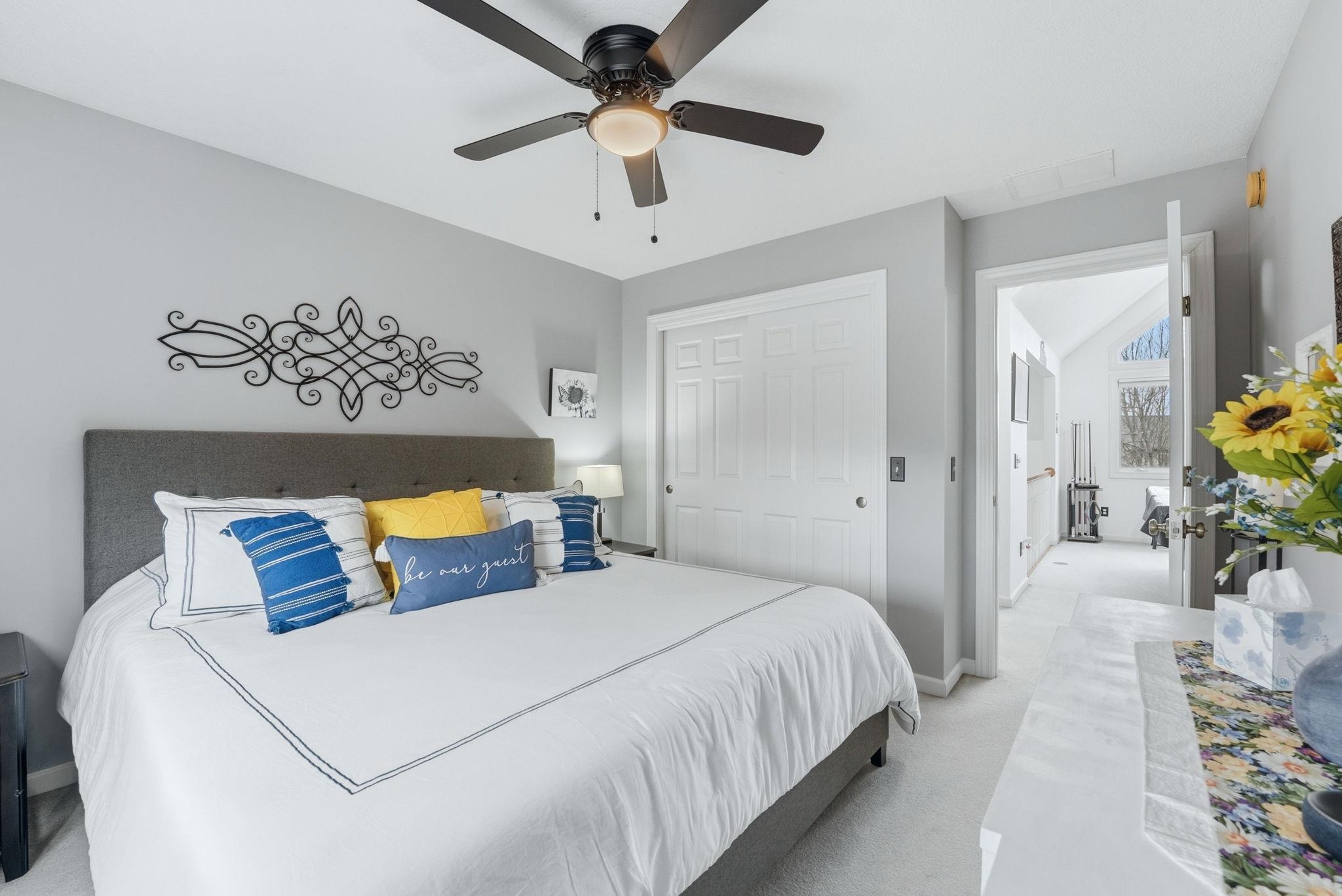 Bedroom featuring light carpet, a ceiling fan, vaulted ceiling, and a closet