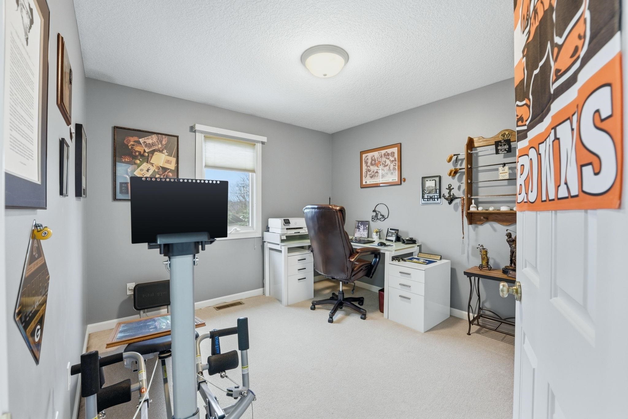Office with light colored carpet and a textured ceiling