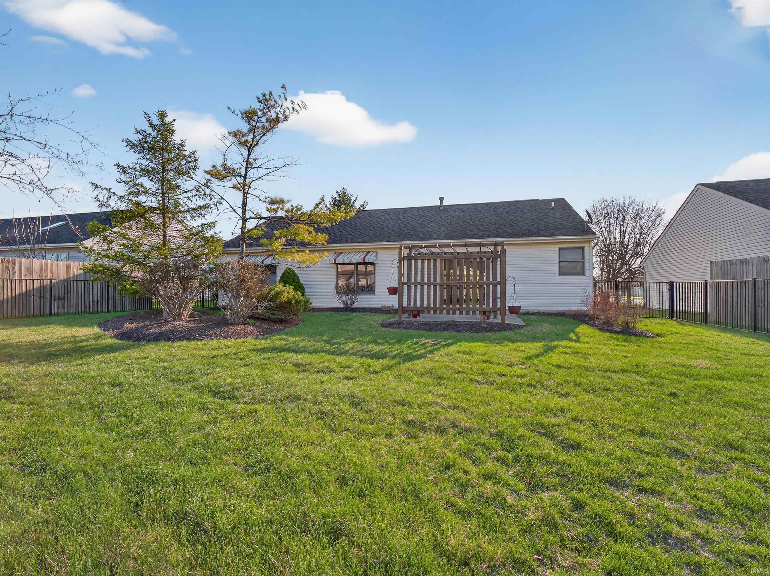 Back of house featuring a fenced backyard and roof with shingles
