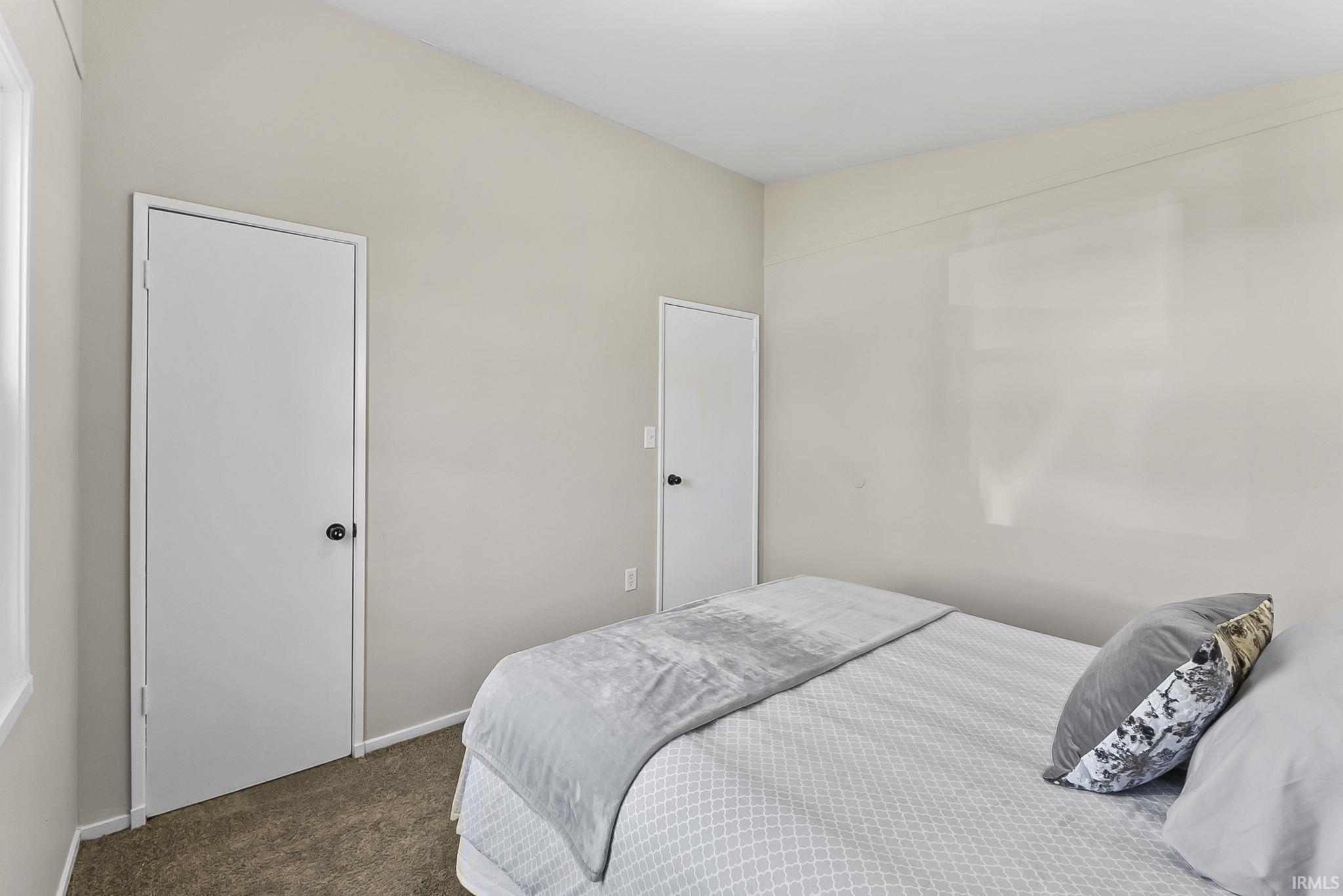 Bedroom featuring carpet and baseboards