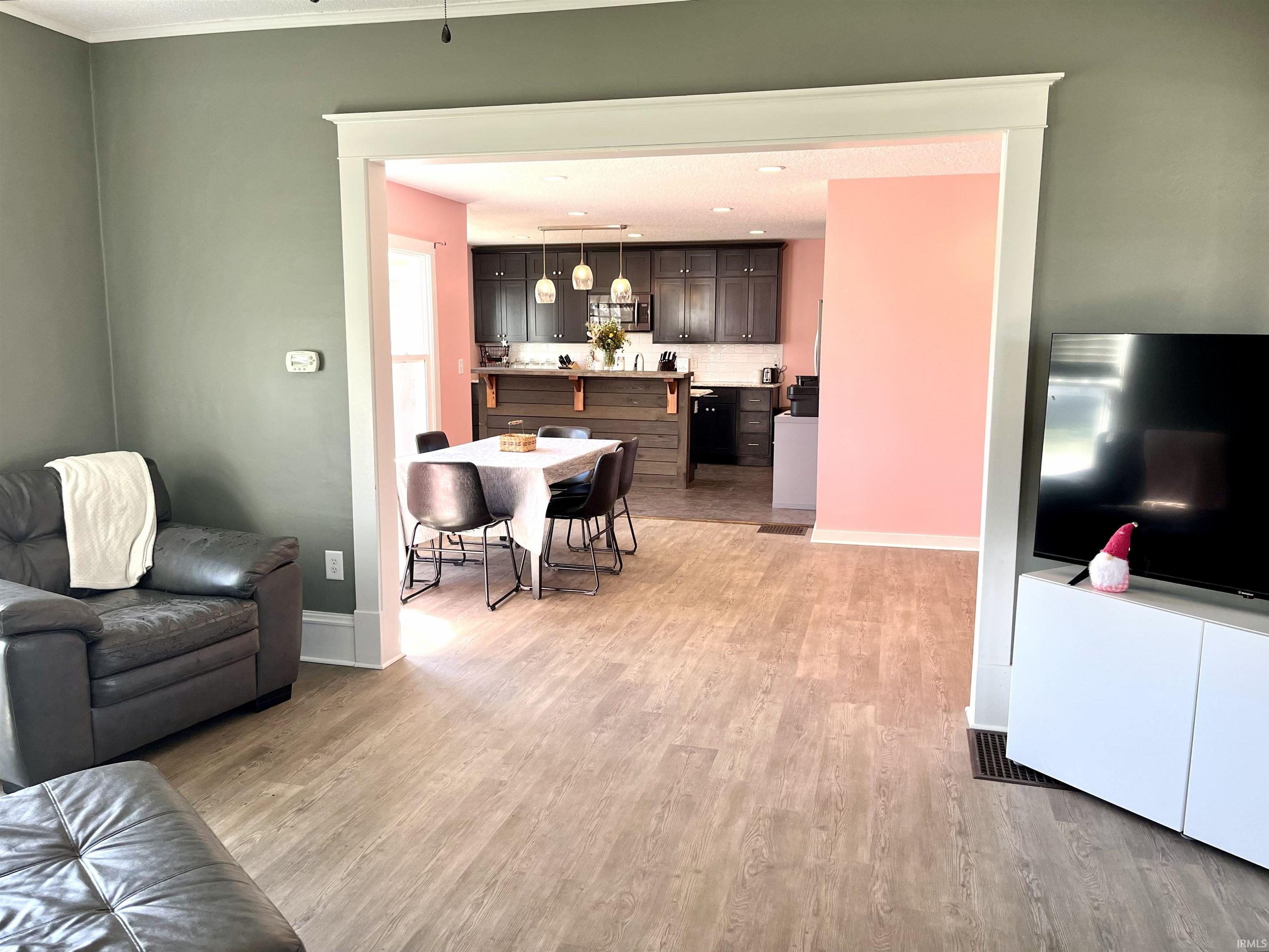 Living area with light wood finished floors and baseboards