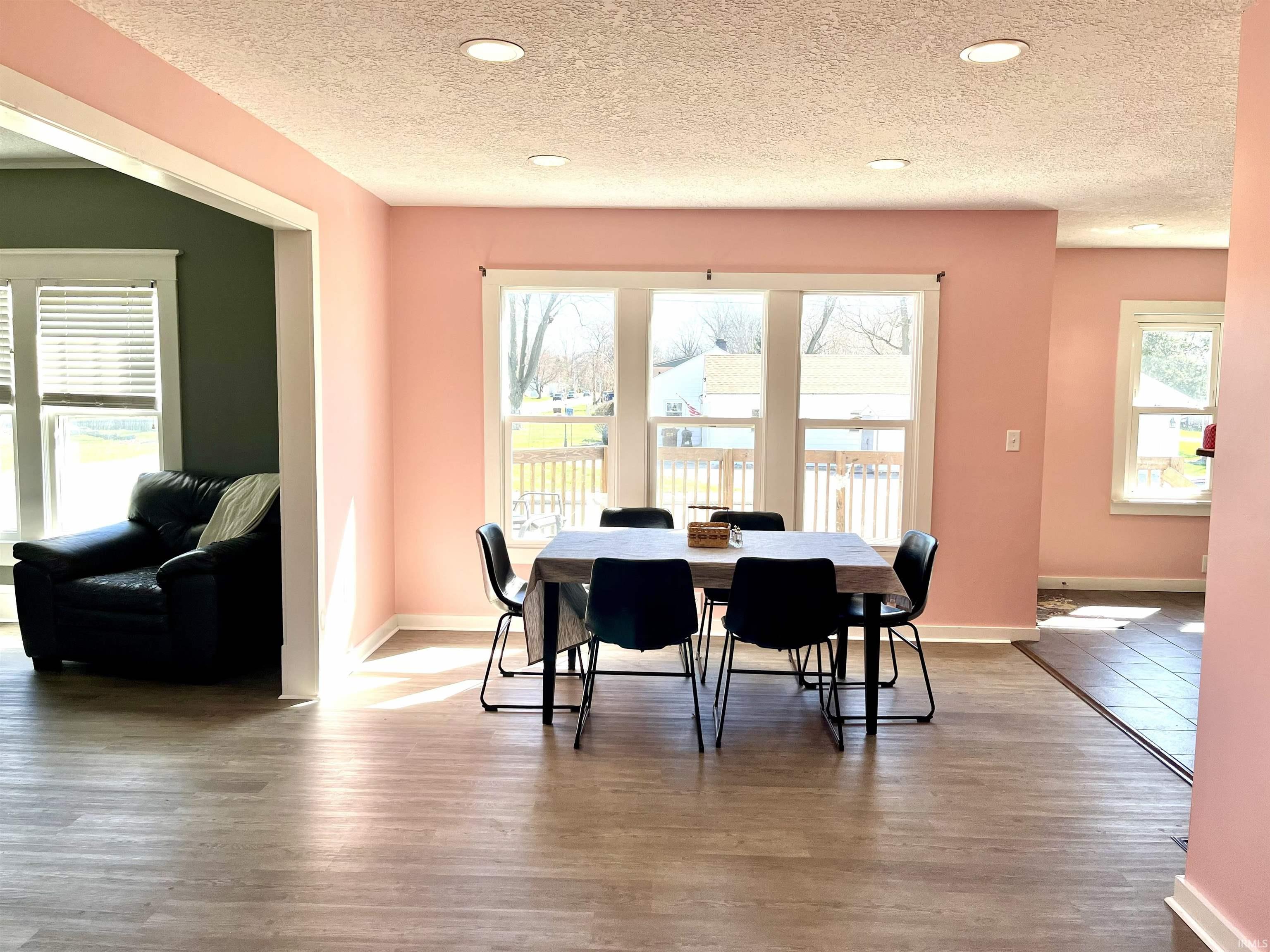 Dining room with wood finished floors, recessed lighting, and a textured ceiling