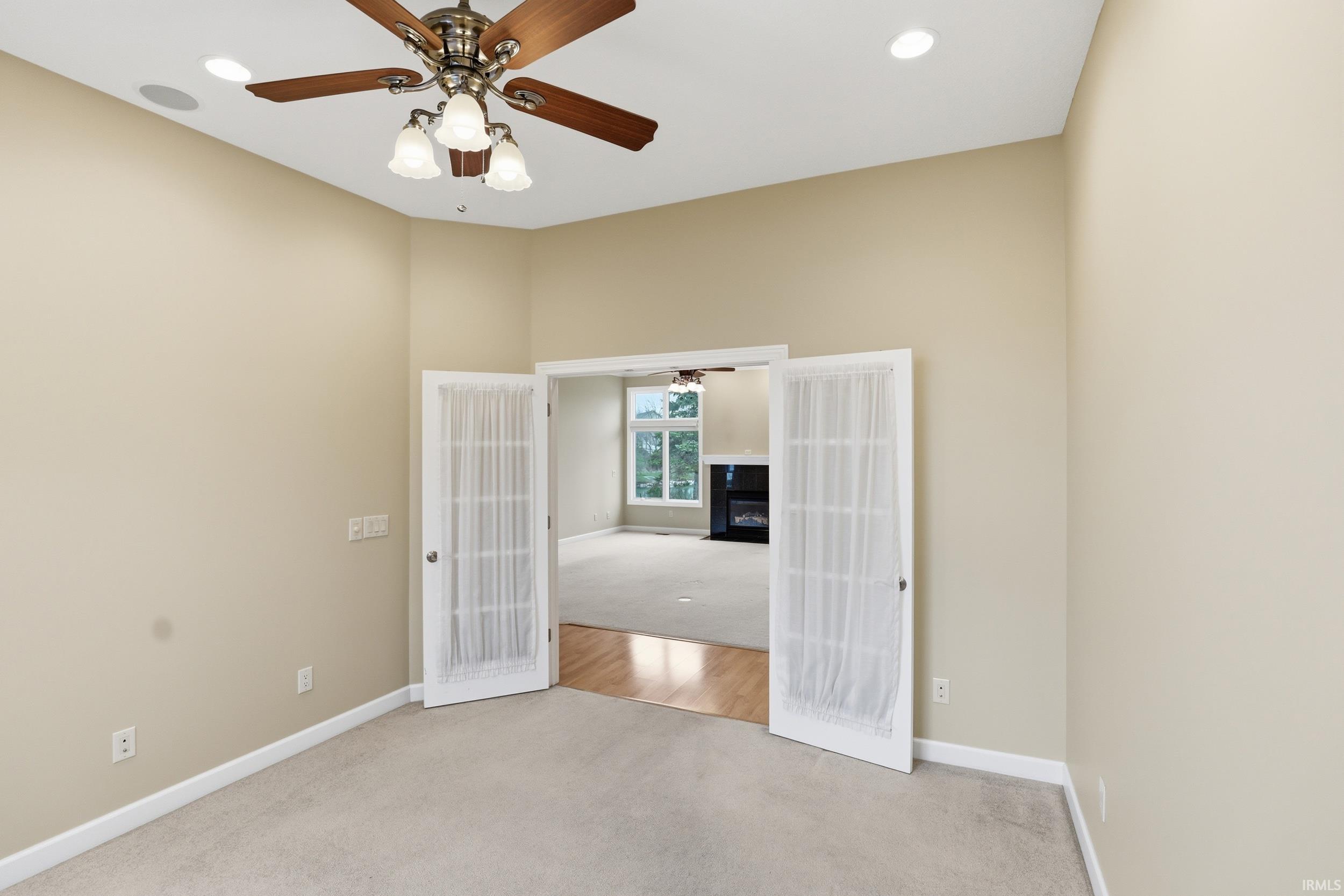 Empty room featuring french doors, light carpet, a ceiling fan, and recessed lighting