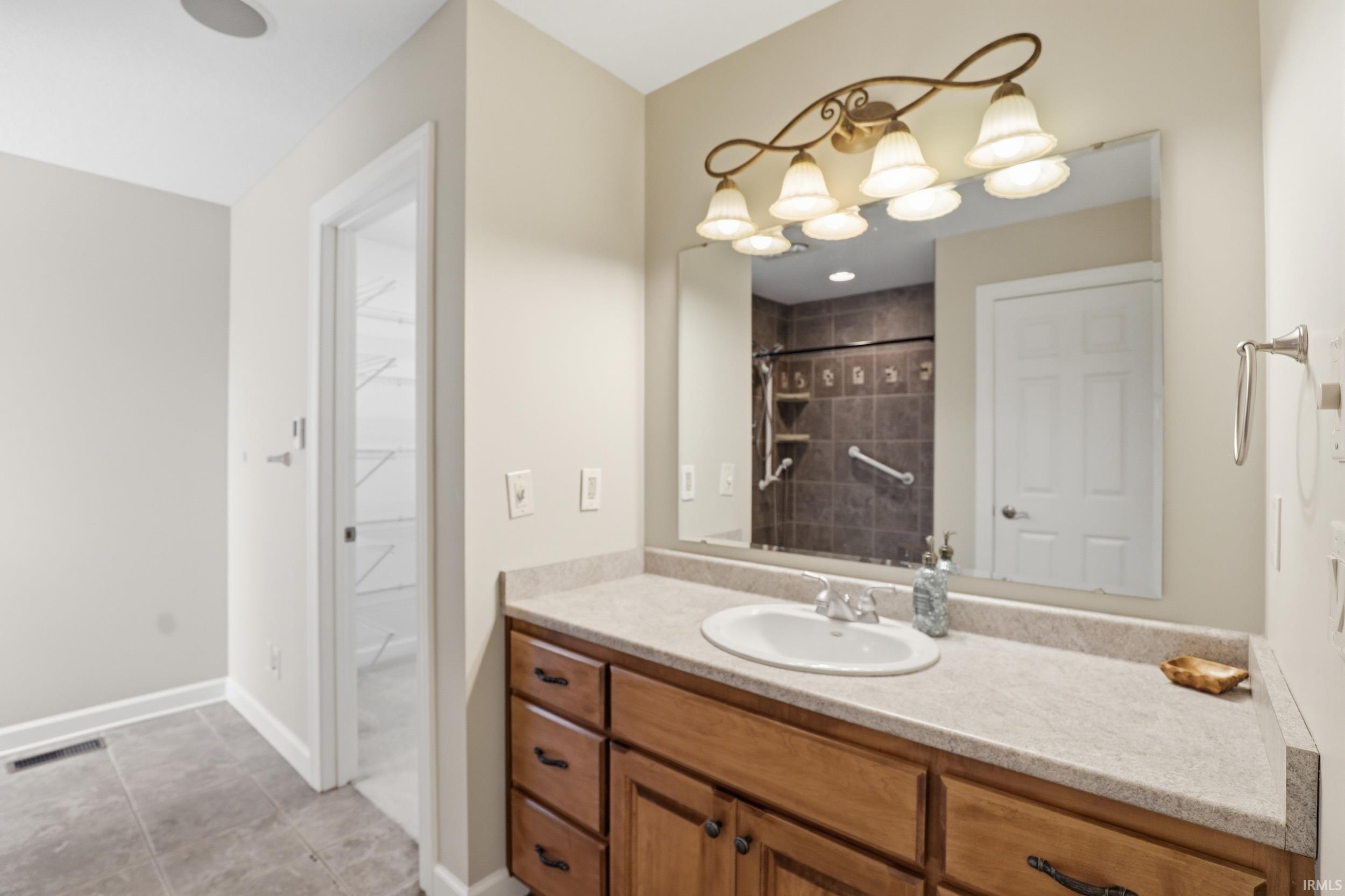 Bathroom with vanity and tiled shower