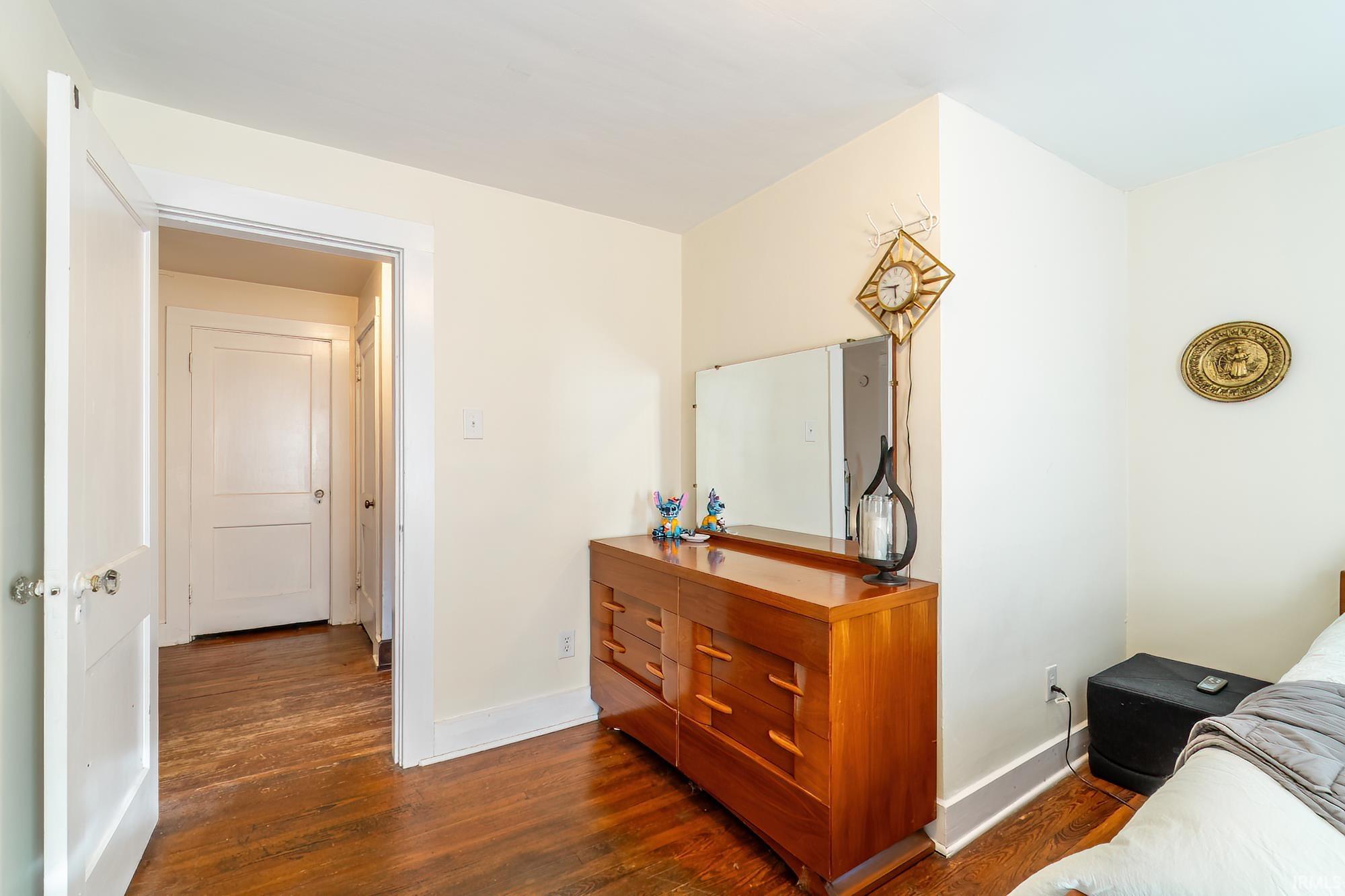 Bedroom featuring dark wood-type flooring and baseboards