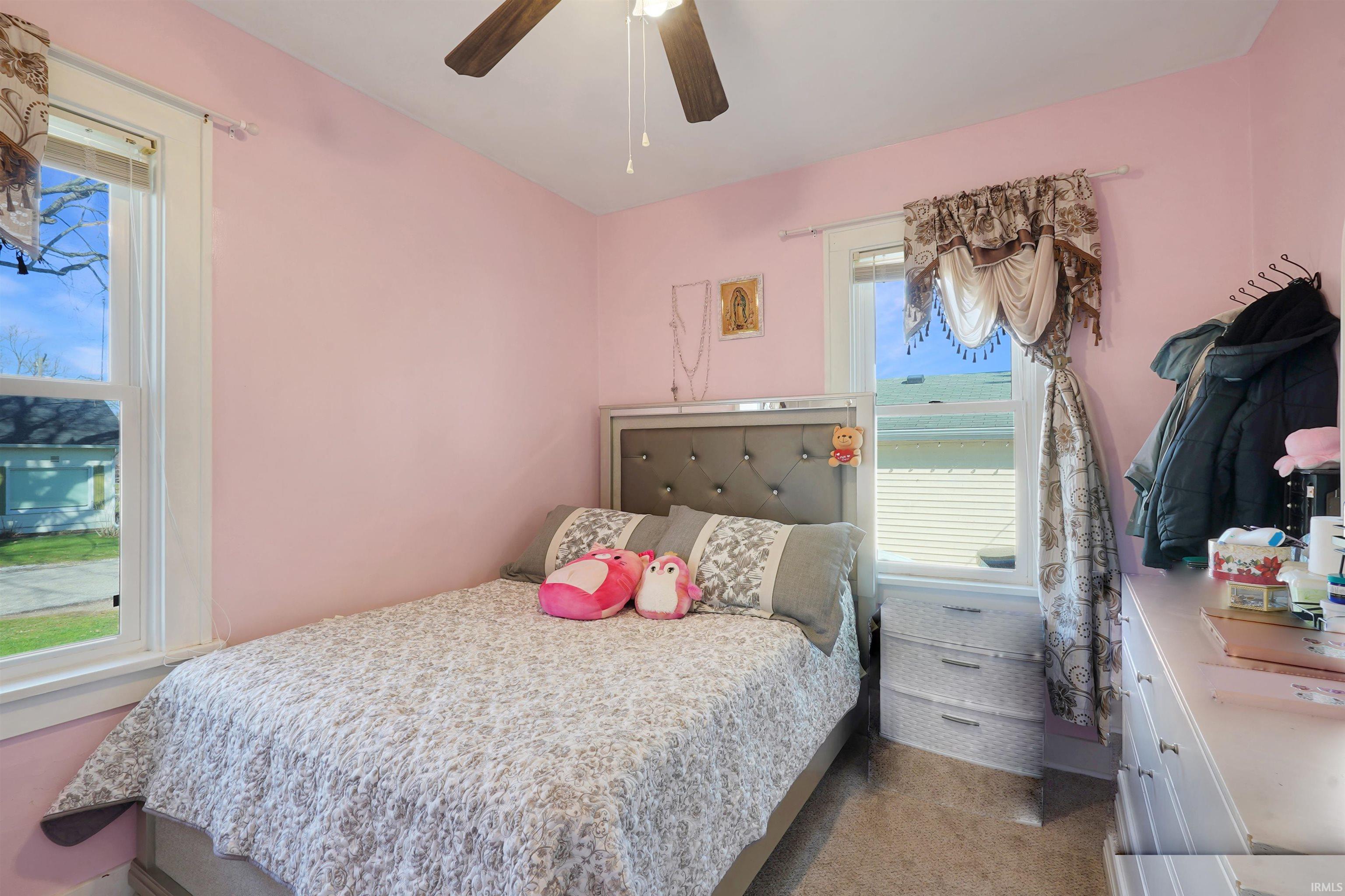 Bedroom with light colored carpet and ceiling fan
