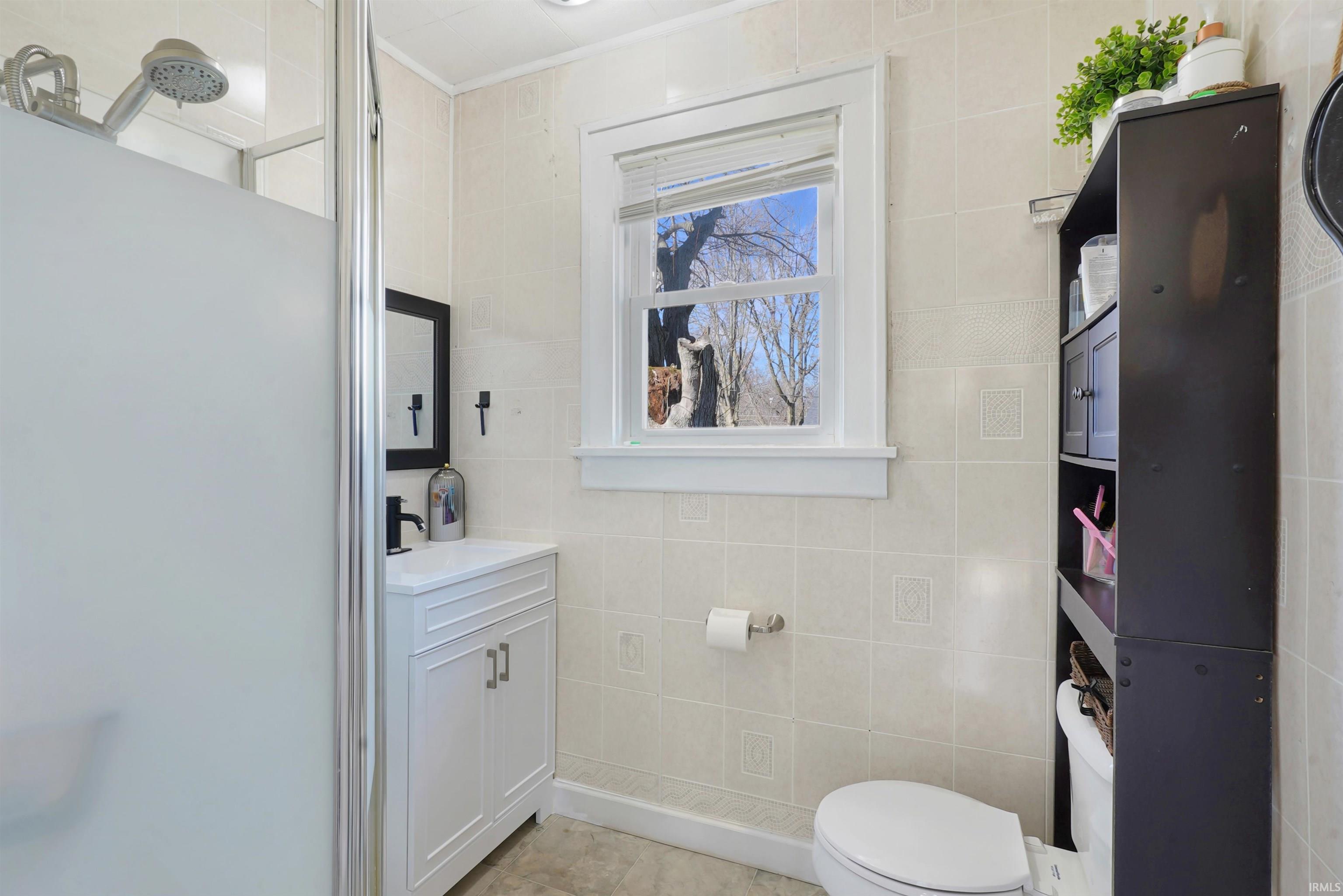 Bathroom with vanity and tile walls