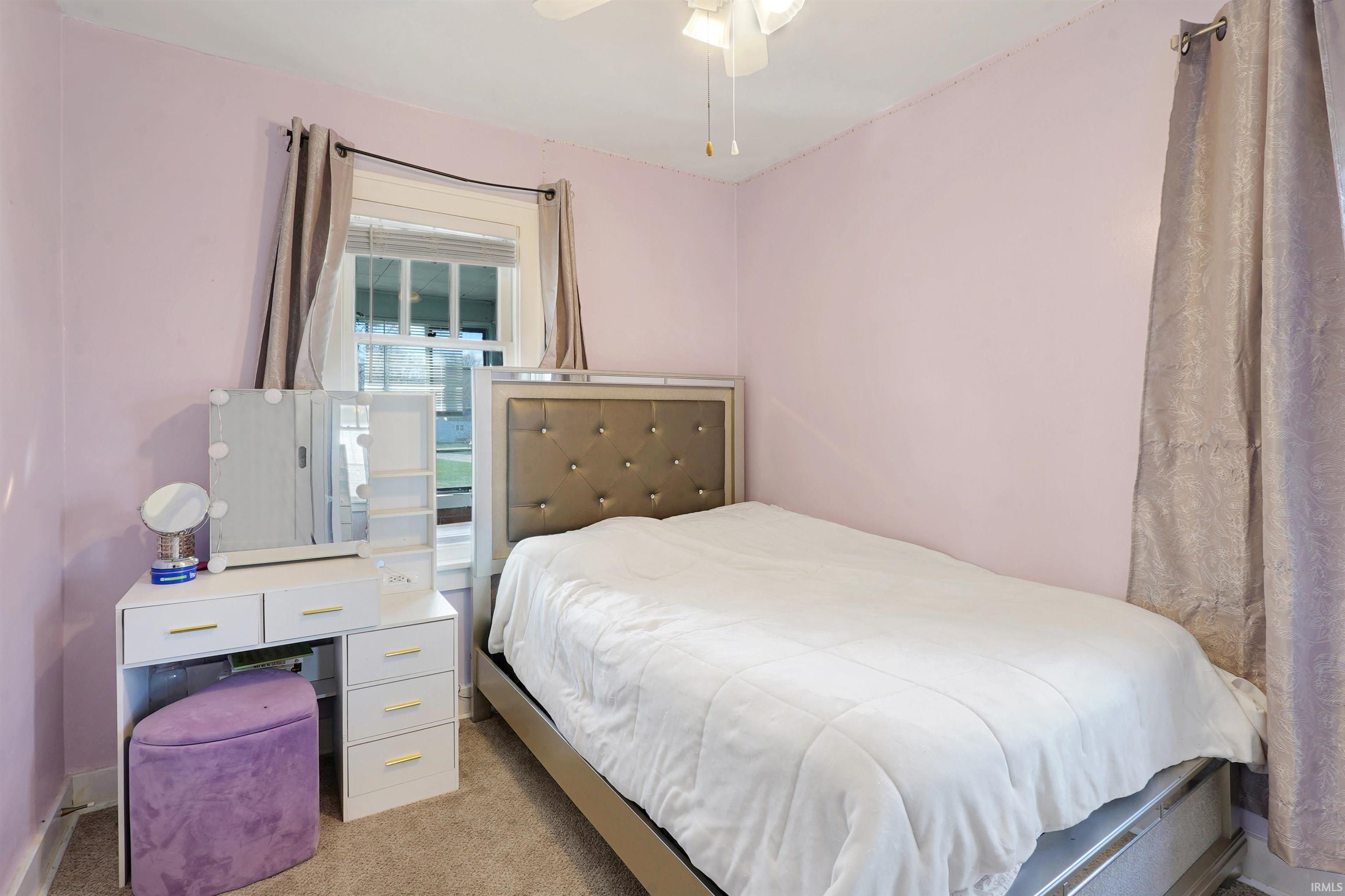 Bedroom with light colored carpet and ceiling fan