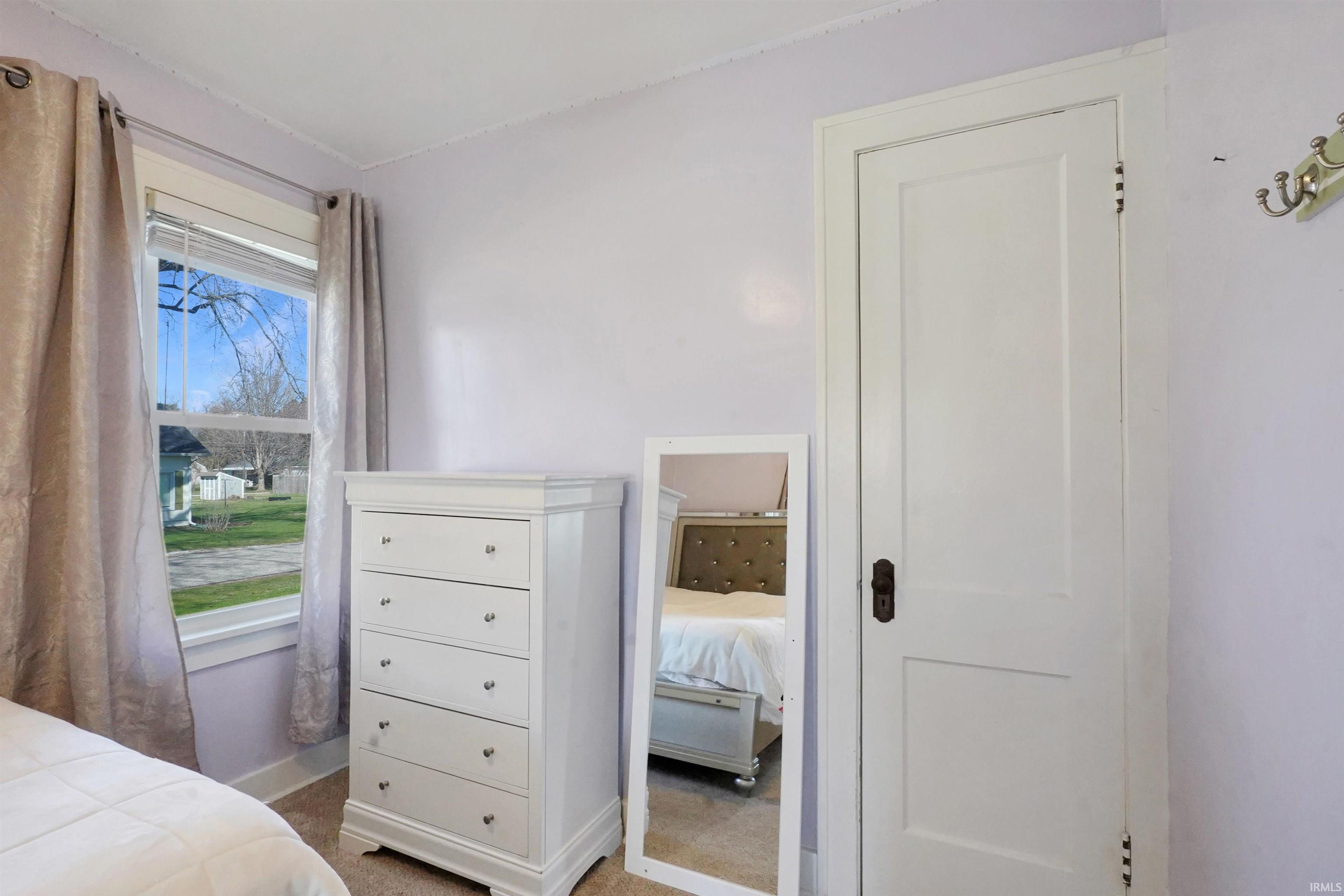 Bedroom featuring light carpet and baseboards
