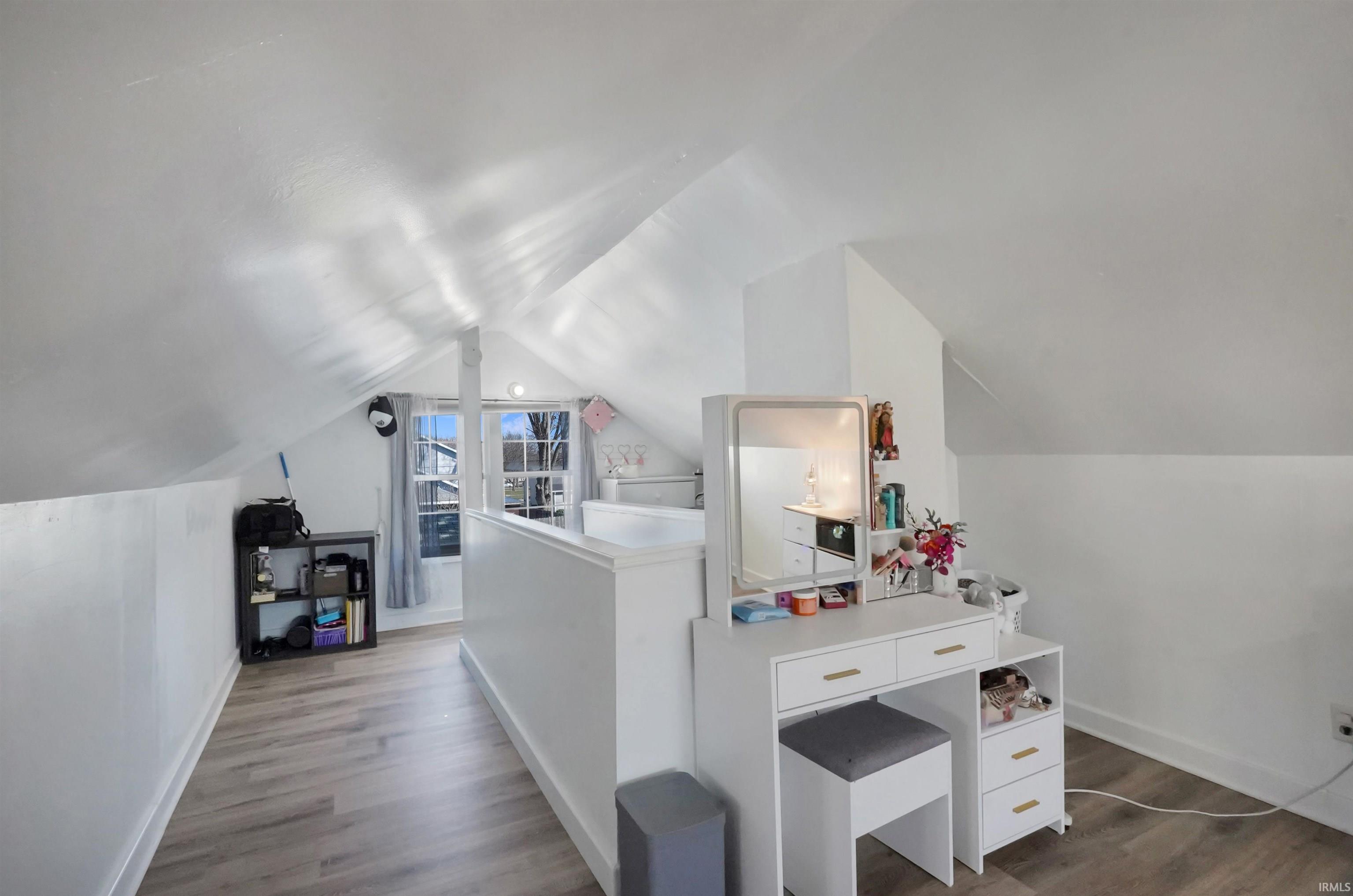 Additional living space featuring dark wood-style floors and baseboards