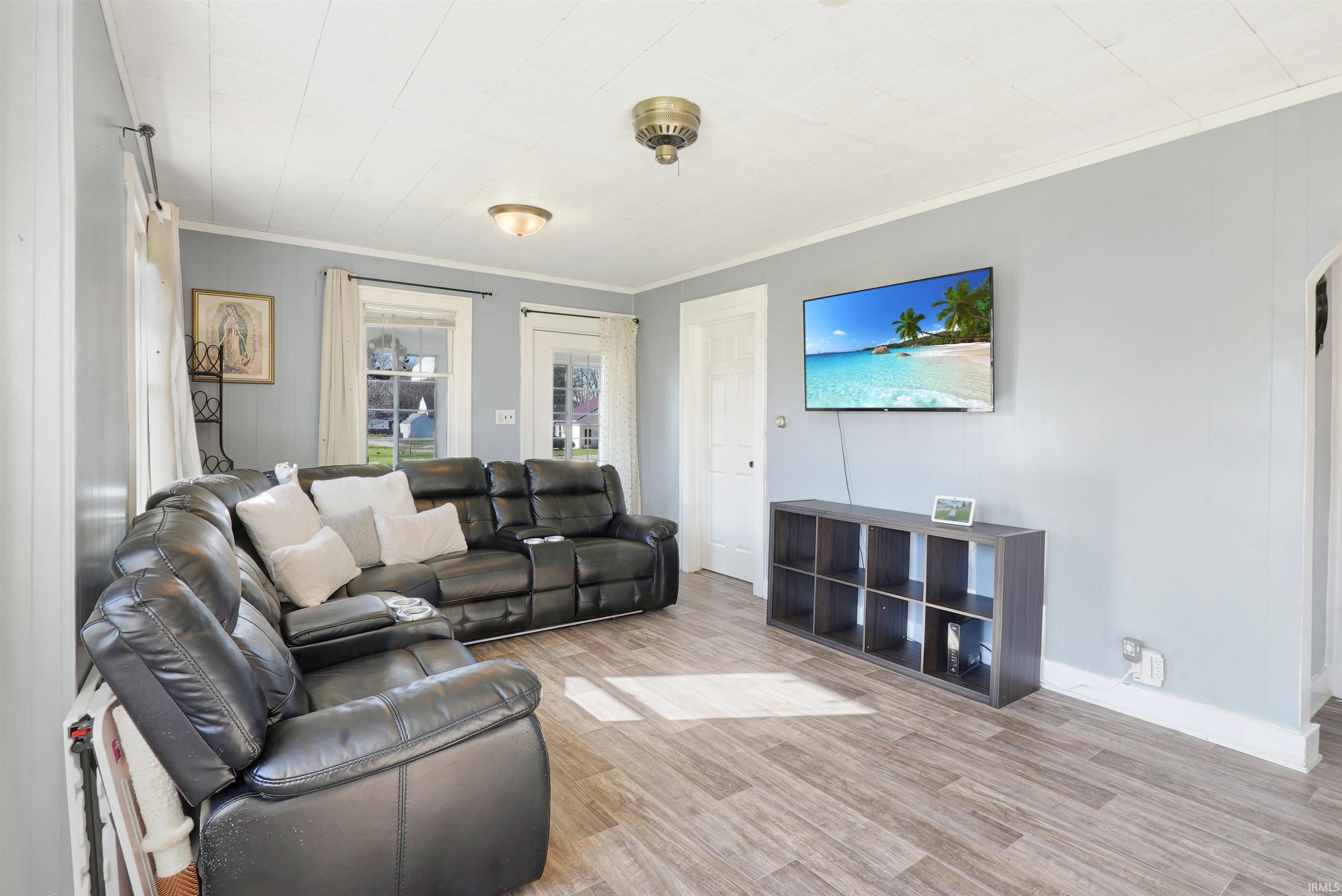 Living room featuring light wood-type flooring and ornamental molding