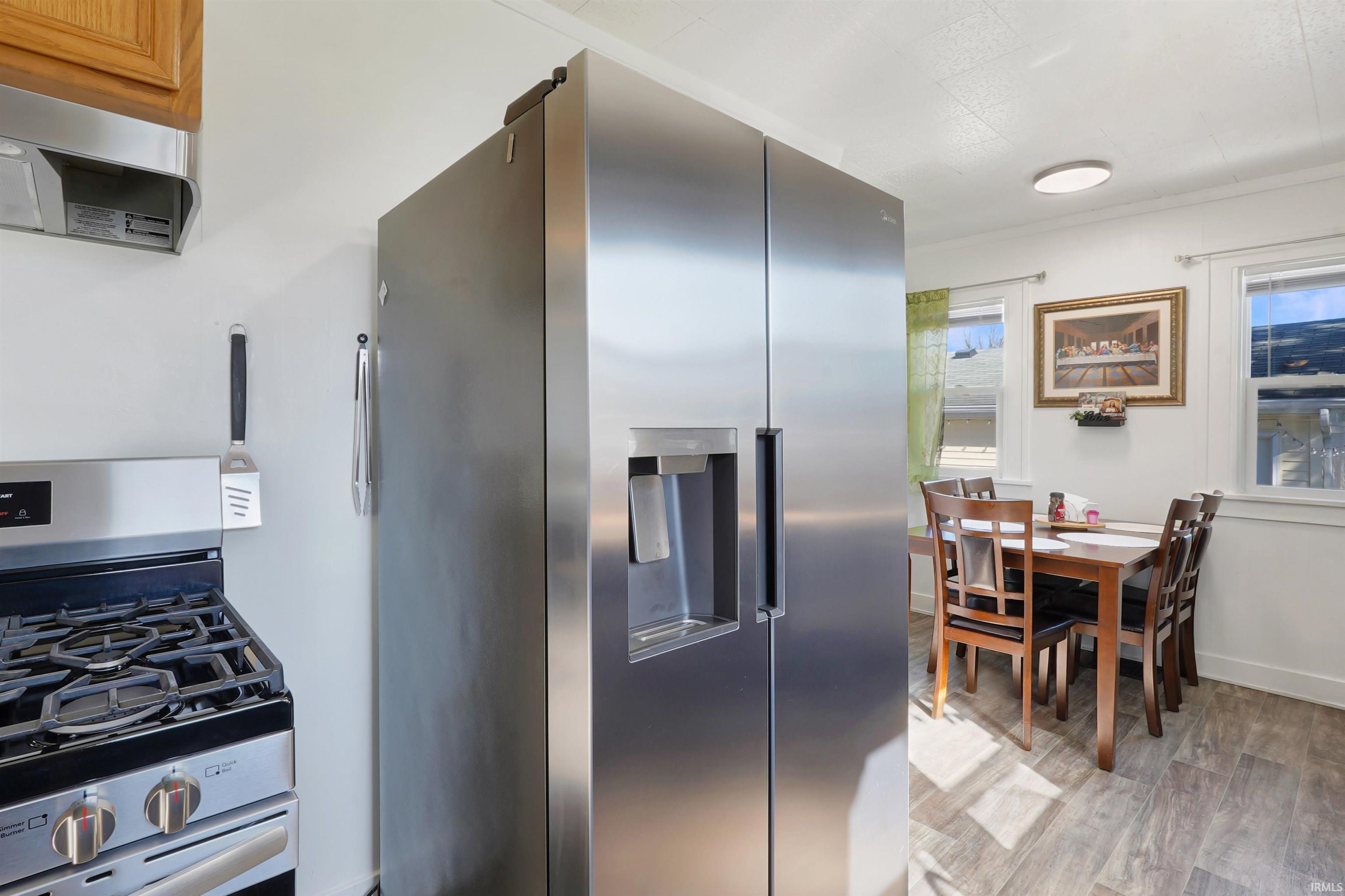 Kitchen featuring stainless steel appliances, light wood finished floors, and range hood
