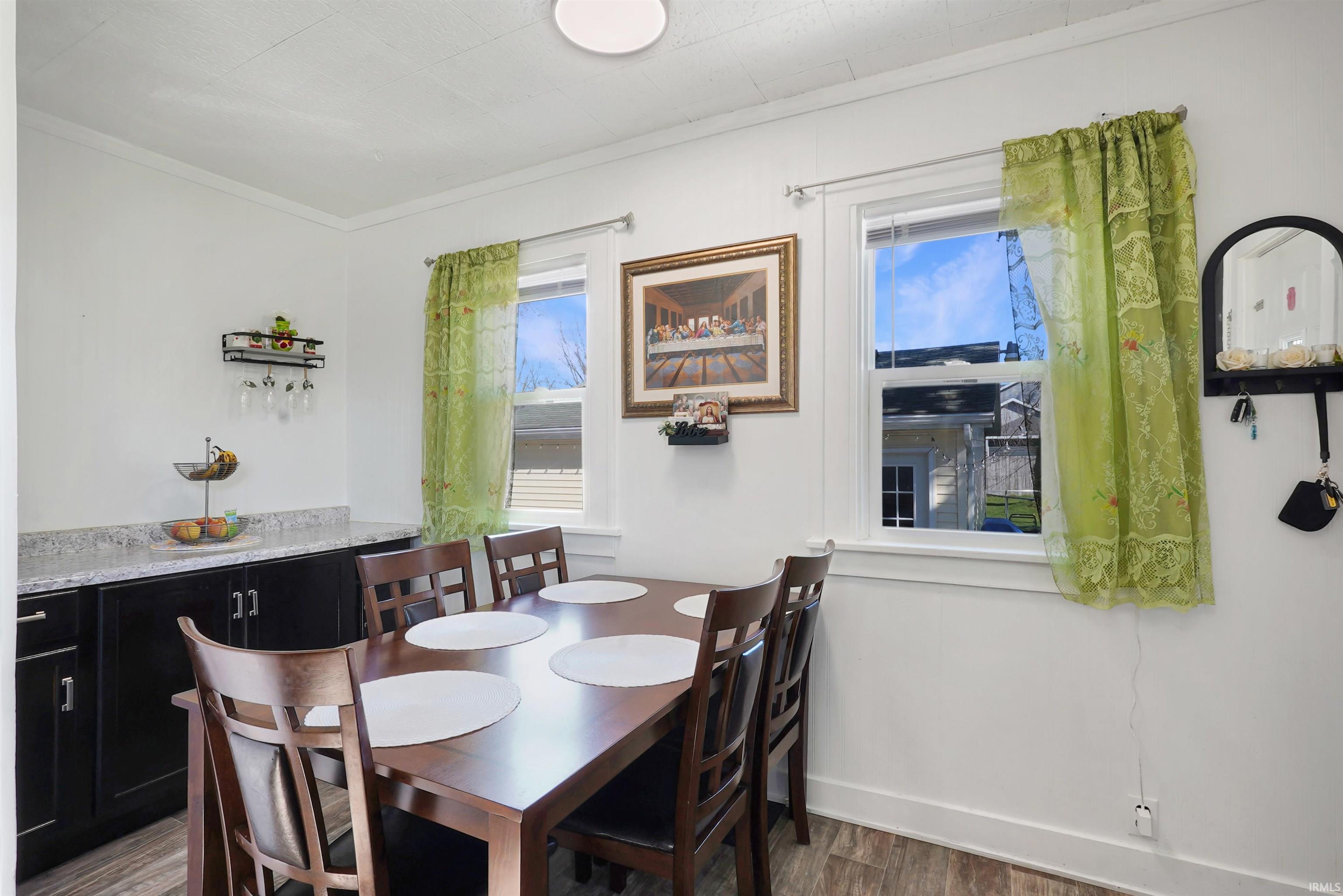 Dining area with wood finished floors and ornamental molding