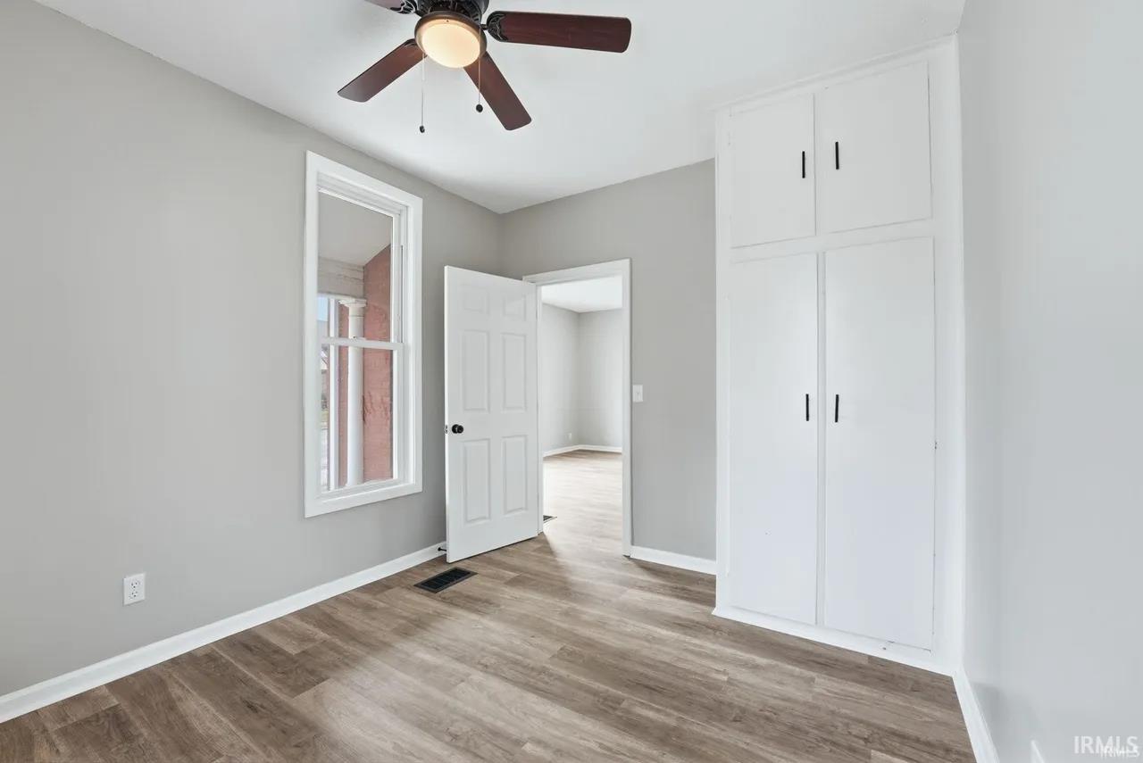 Unfurnished bedroom featuring light wood-style floors, a ceiling fan, and a closet