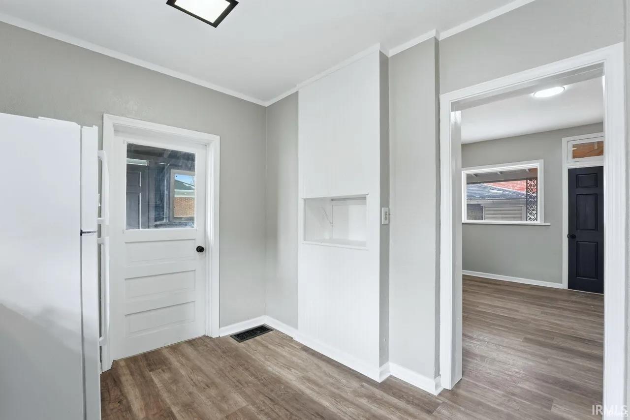 Entrance foyer featuring light wood-style floors and crown molding