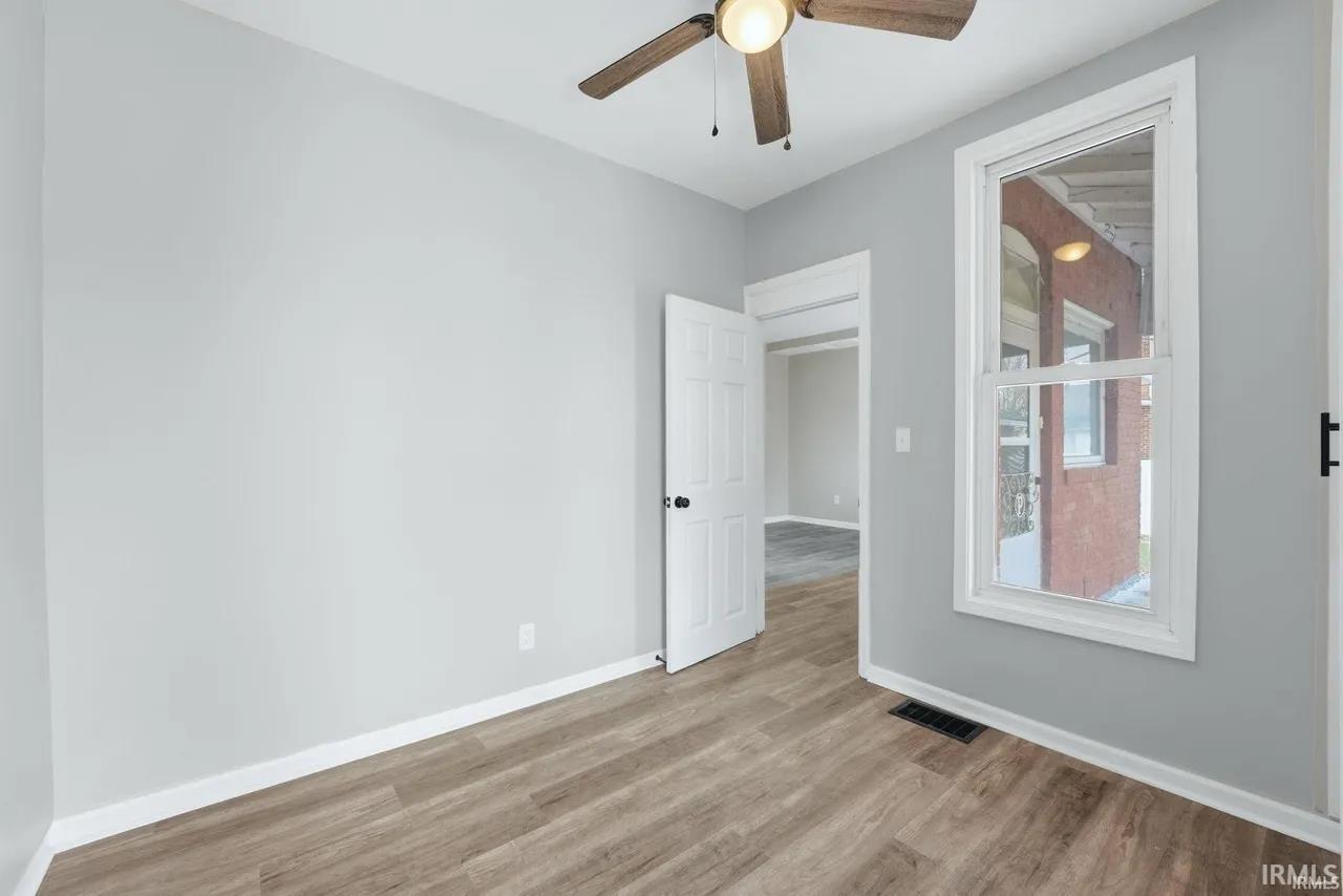 Spare room with a ceiling fan and light wood-style flooring