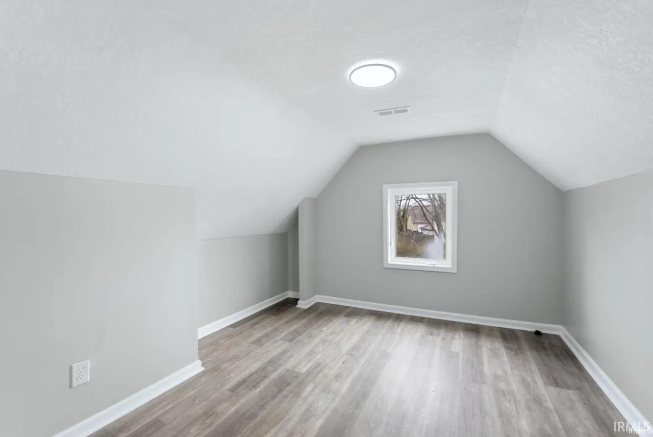 Additional living space with light wood finished floors and a textured ceiling