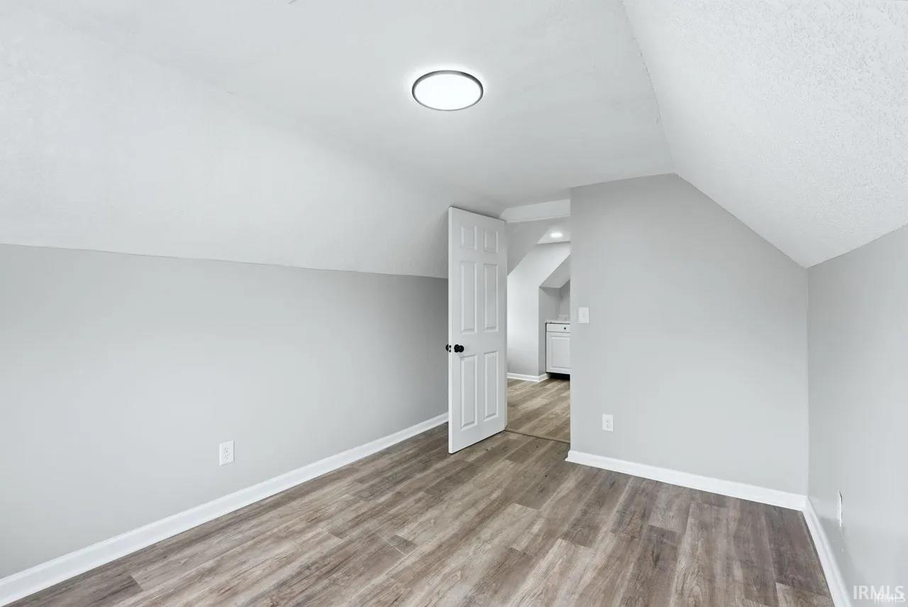 Bonus room with baseboards and light wood-style floors
