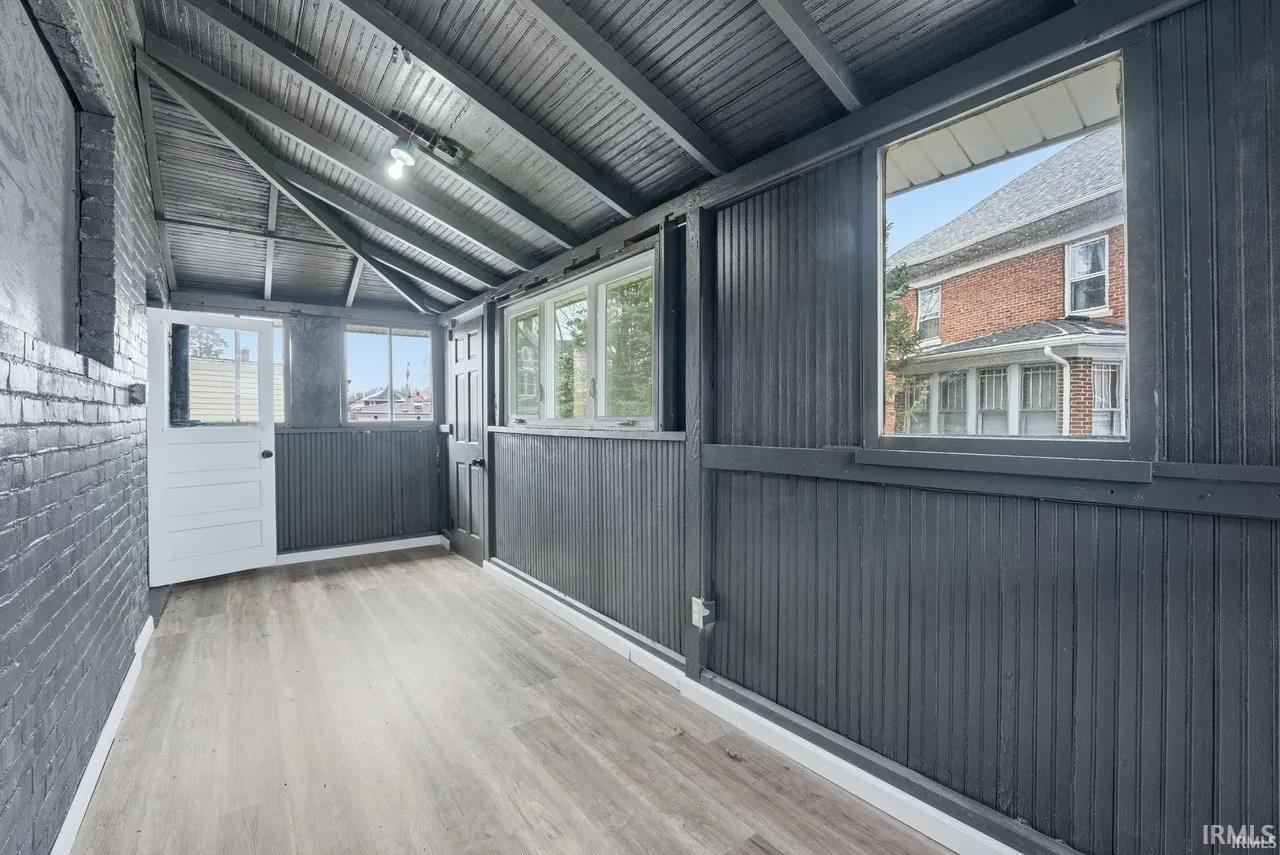 Unfurnished sunroom with lofted ceiling with beams