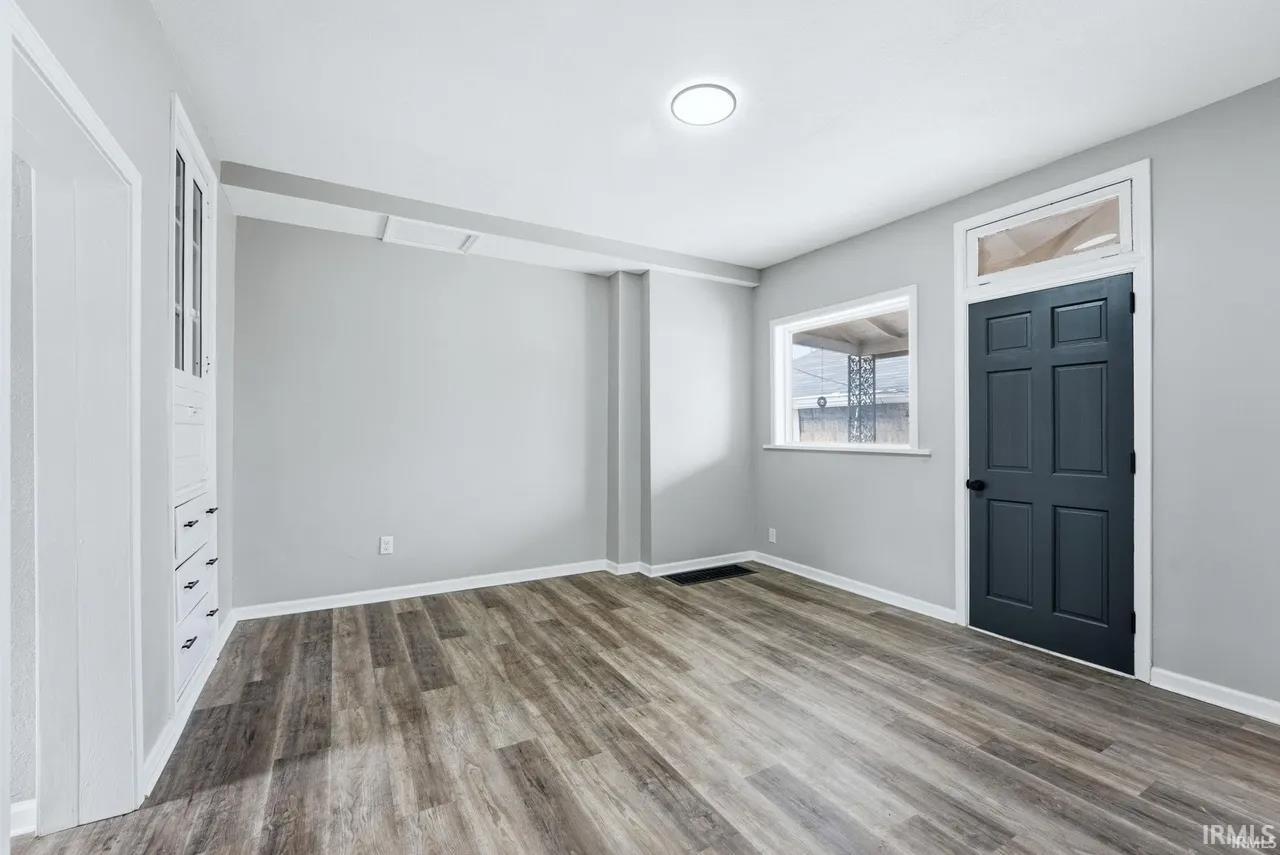 Foyer featuring dark wood-type flooring and baseboards