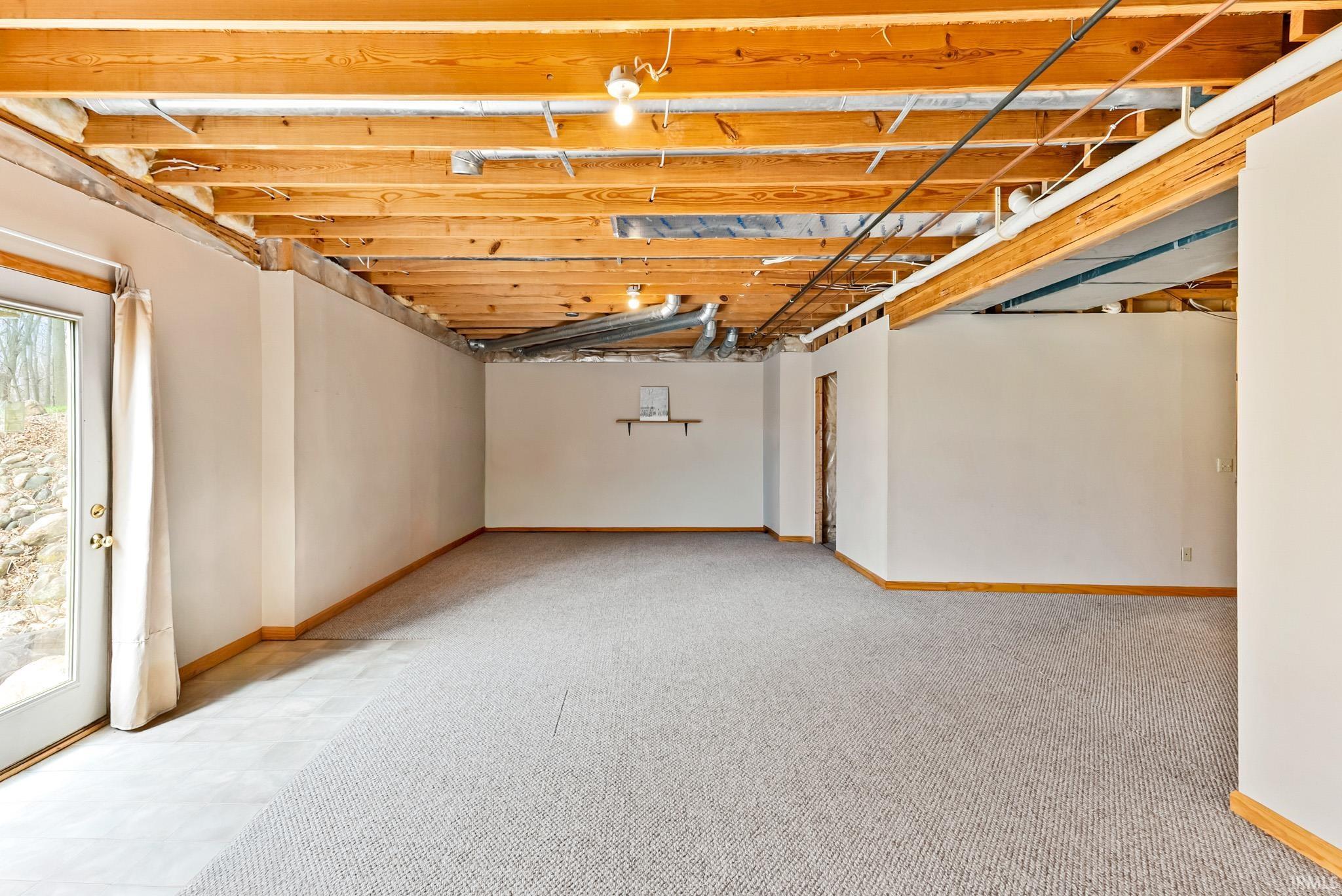 Below grade area with light colored carpet and baseboards