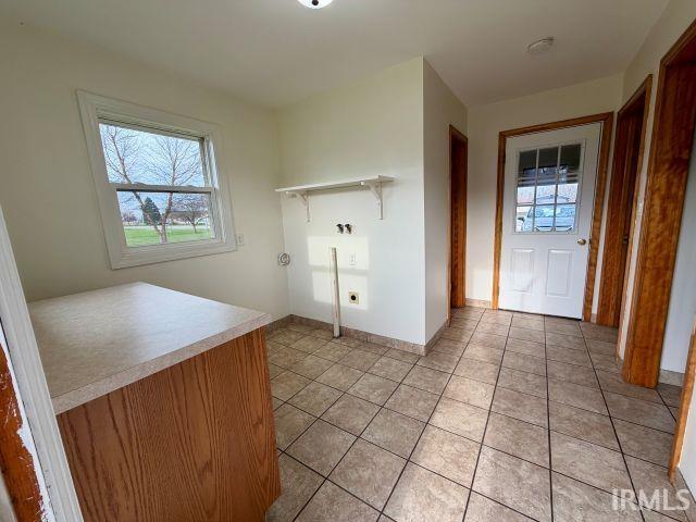 Laundry room with light tile patterned floors and washer hookup