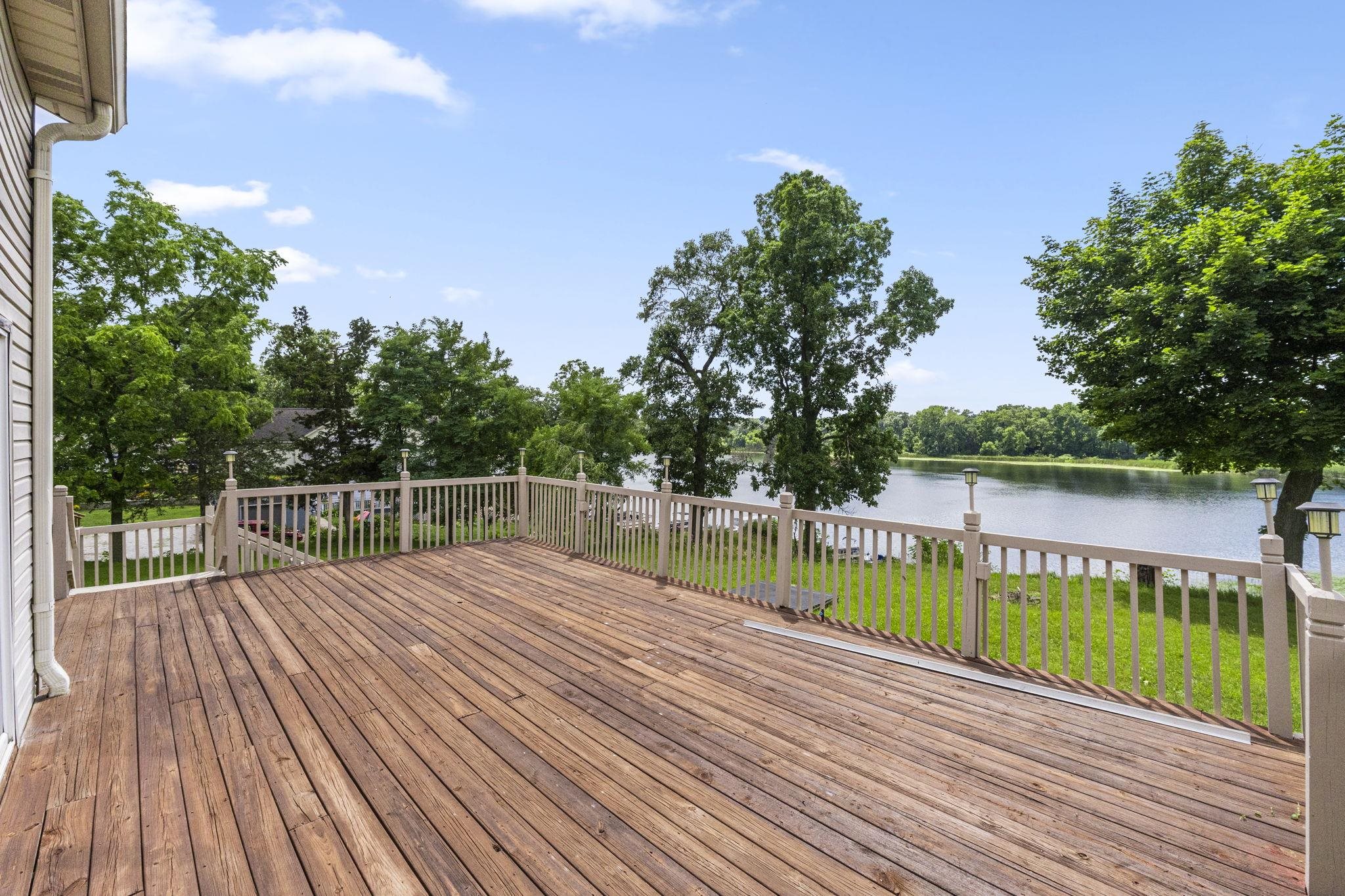 Deck with a water view and a yard