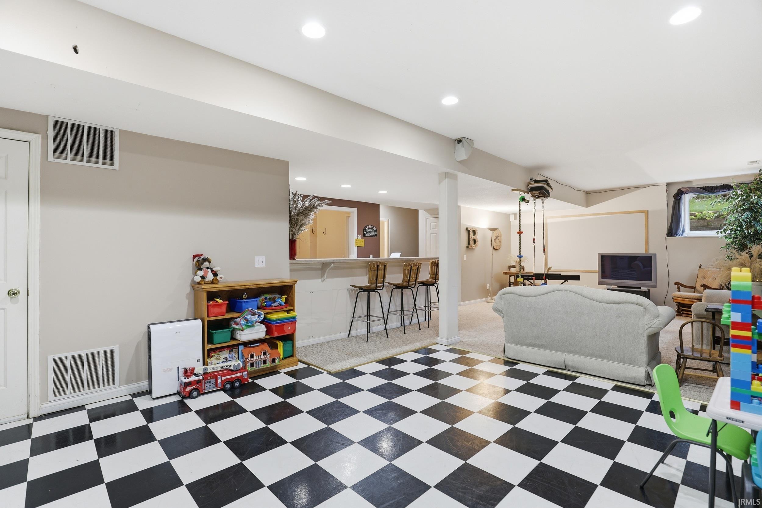 Rec room featuring a dry bar, light flooring, and recessed lighting