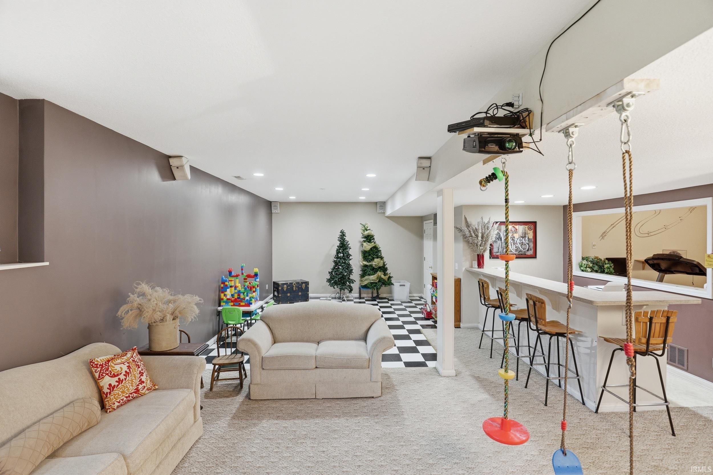 Living area featuring light flooring, bar, and recessed lighting