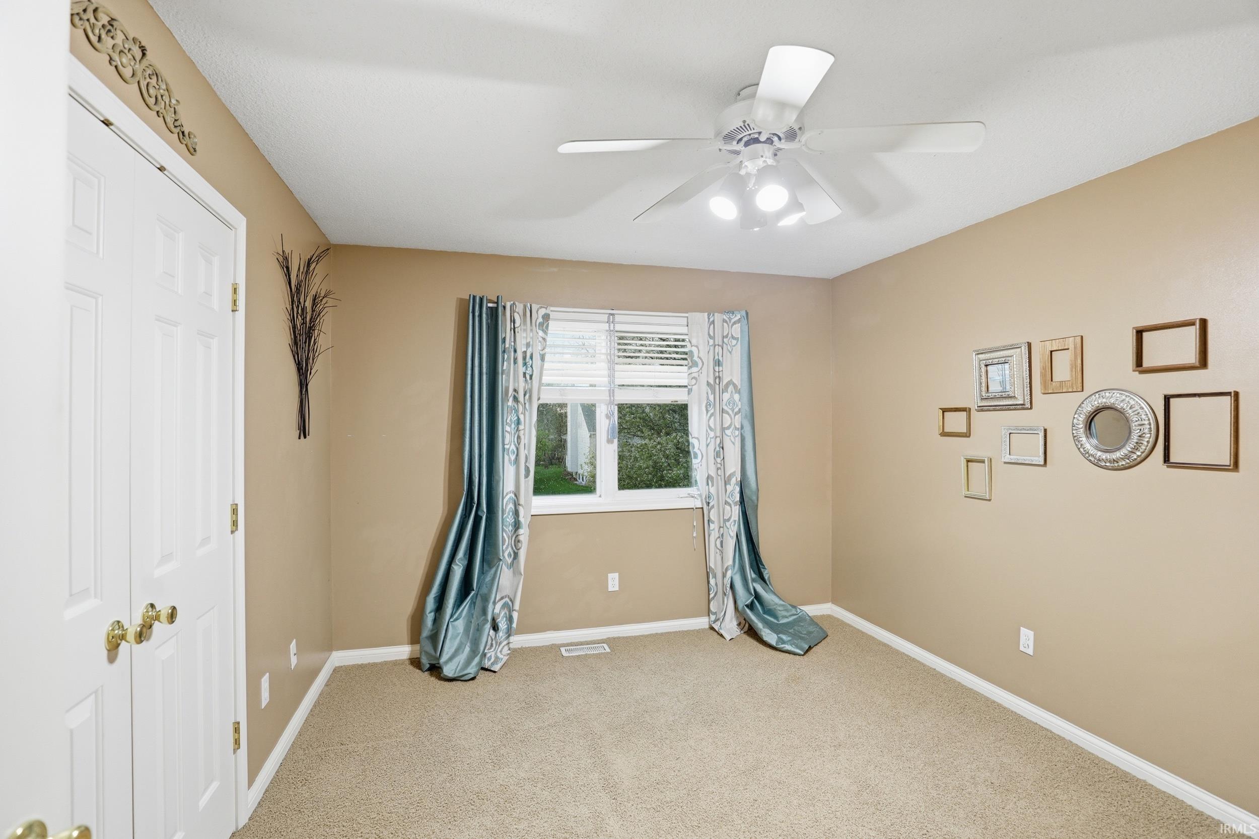 Unfurnished bedroom with a closet, light carpet, and a ceiling fan